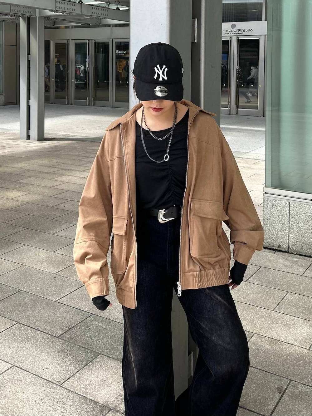 ブラック系のデニムパンツ、イエロー系のブルゾン、ブラック系のTシャツ/カットソーを着用したレディースの秋コーディネートの8枚目の写真