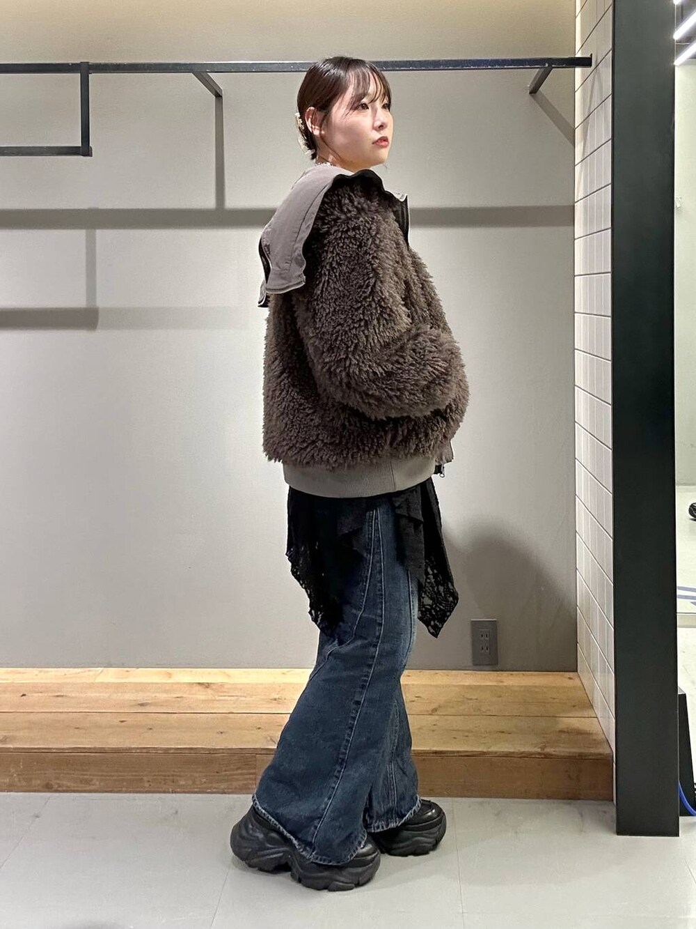 ブラック系のスニーカー、ブルー系のデニムパンツ、ブラック系のブルゾンを着用したレディースの秋コーディネートの4枚目の写真