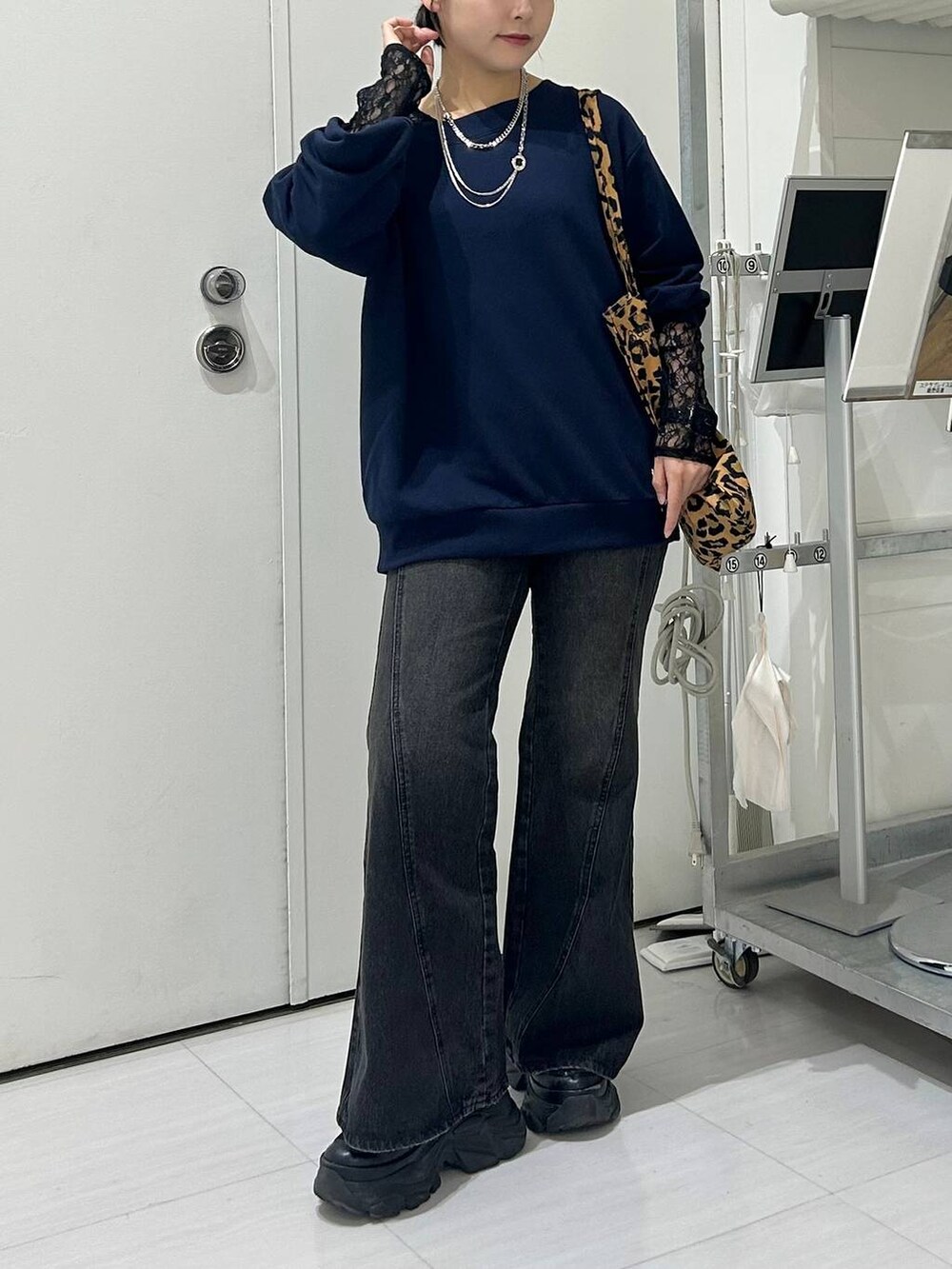 ブラック系のスニーカー、ブルー系のデニムパンツ、ブラック系のTシャツ/カットソーを着用したレディースの秋コーディネートの3枚目の写真