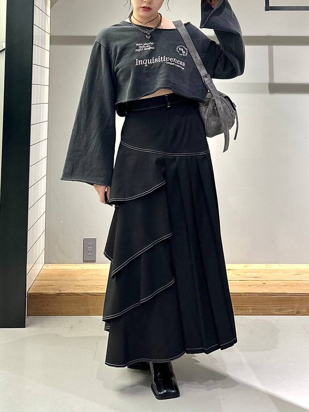 ブラック系のブーツ、ブラック系のスカート、グレー系のスウェットを着用したレディースの秋コーディネートの5枚目の写真