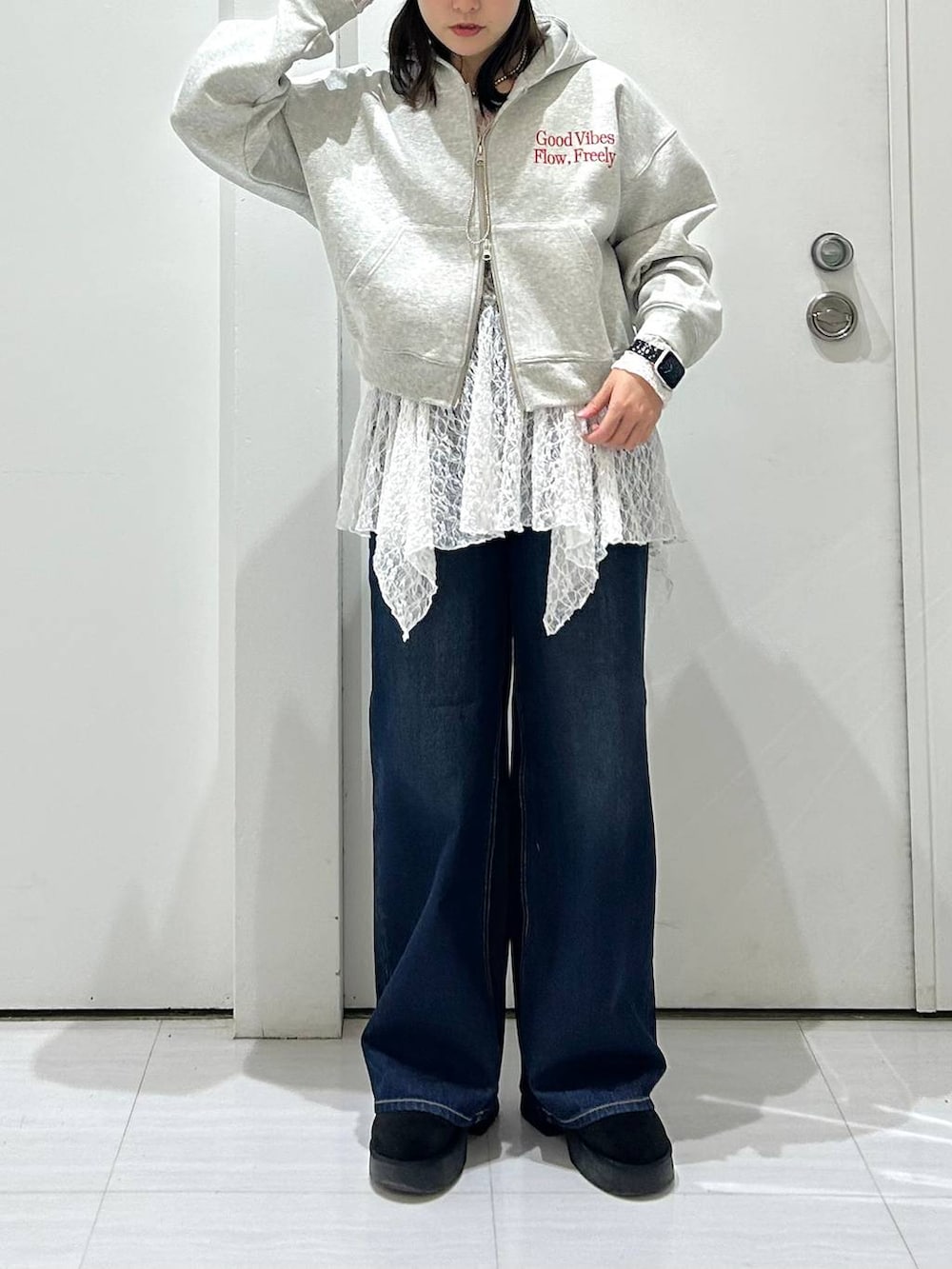 ブルー系のスラックス、グレー系のパーカー、ホワイト系のチュニックを着用したレディースの冬コーディネートの3枚目の写真