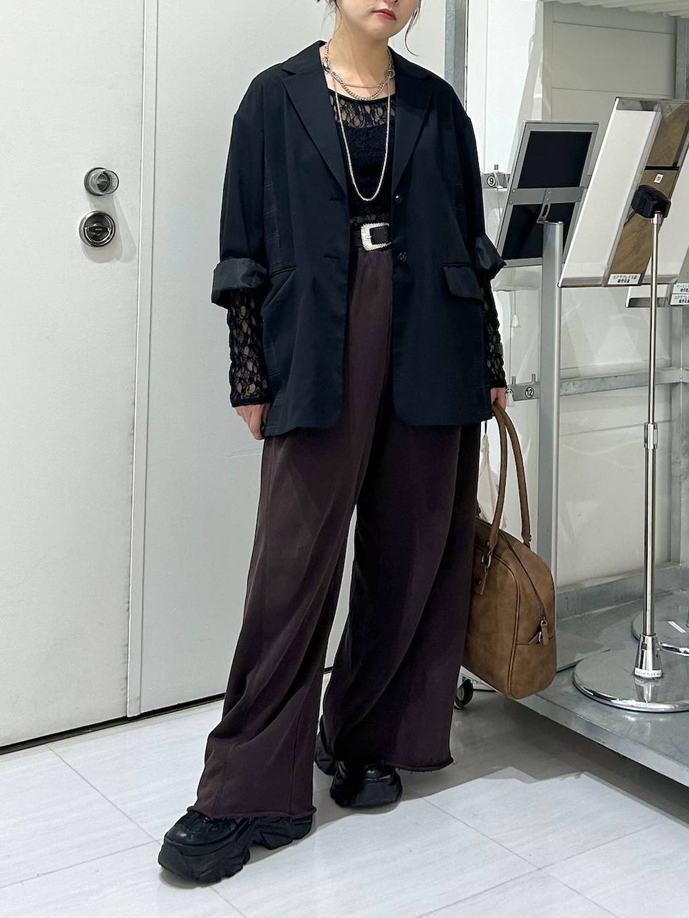 ベージュ系のボストンバッグ、ブラック系のスウェットパンツ、ブラック系のテーラードジャケットを着用したレディースの秋コーディネートの4枚目の写真