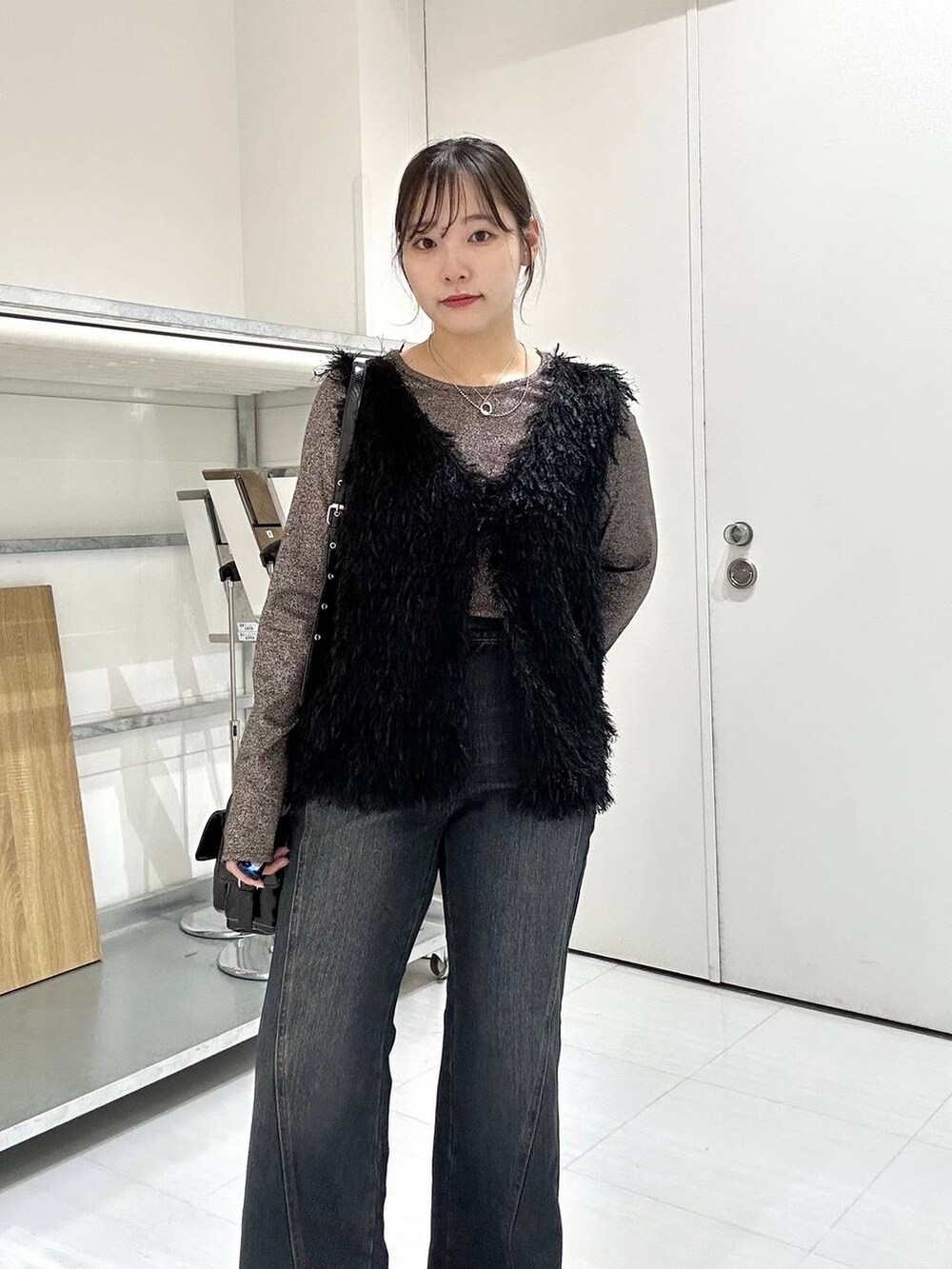 ブラウン系のTシャツ/カットソー、ブルー系のデニムパンツ、ブラック系のベストを着用したレディースの秋コーディネートの7枚目の写真