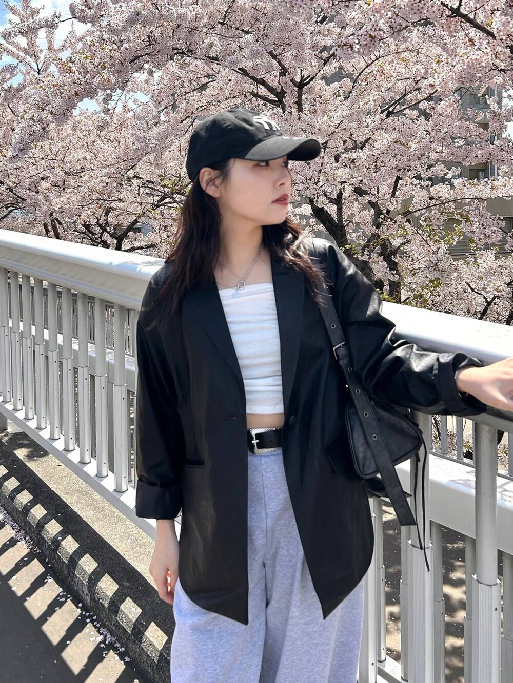 ブラック系のスニーカー、ブラック系のテーラードジャケット、グレー系のスウェットパンツを着用したレディースの春コーディネートの5枚目の写真