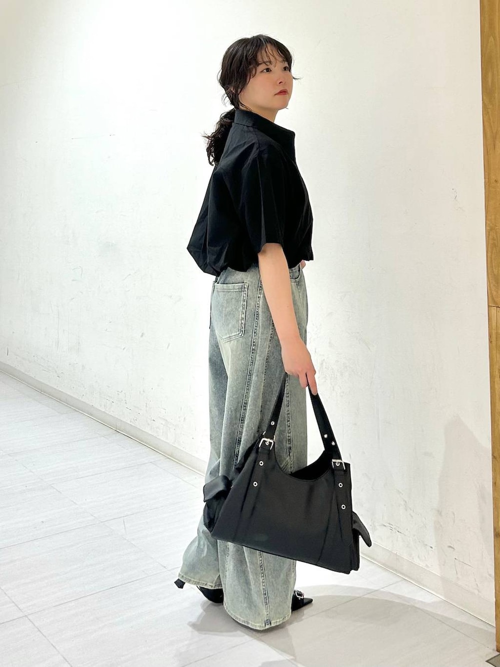 ブルー系のデニムパンツ、ブラック系のサンダル、ブラック系のベルトを着用したレディースの夏コーディネートの6枚目の写真