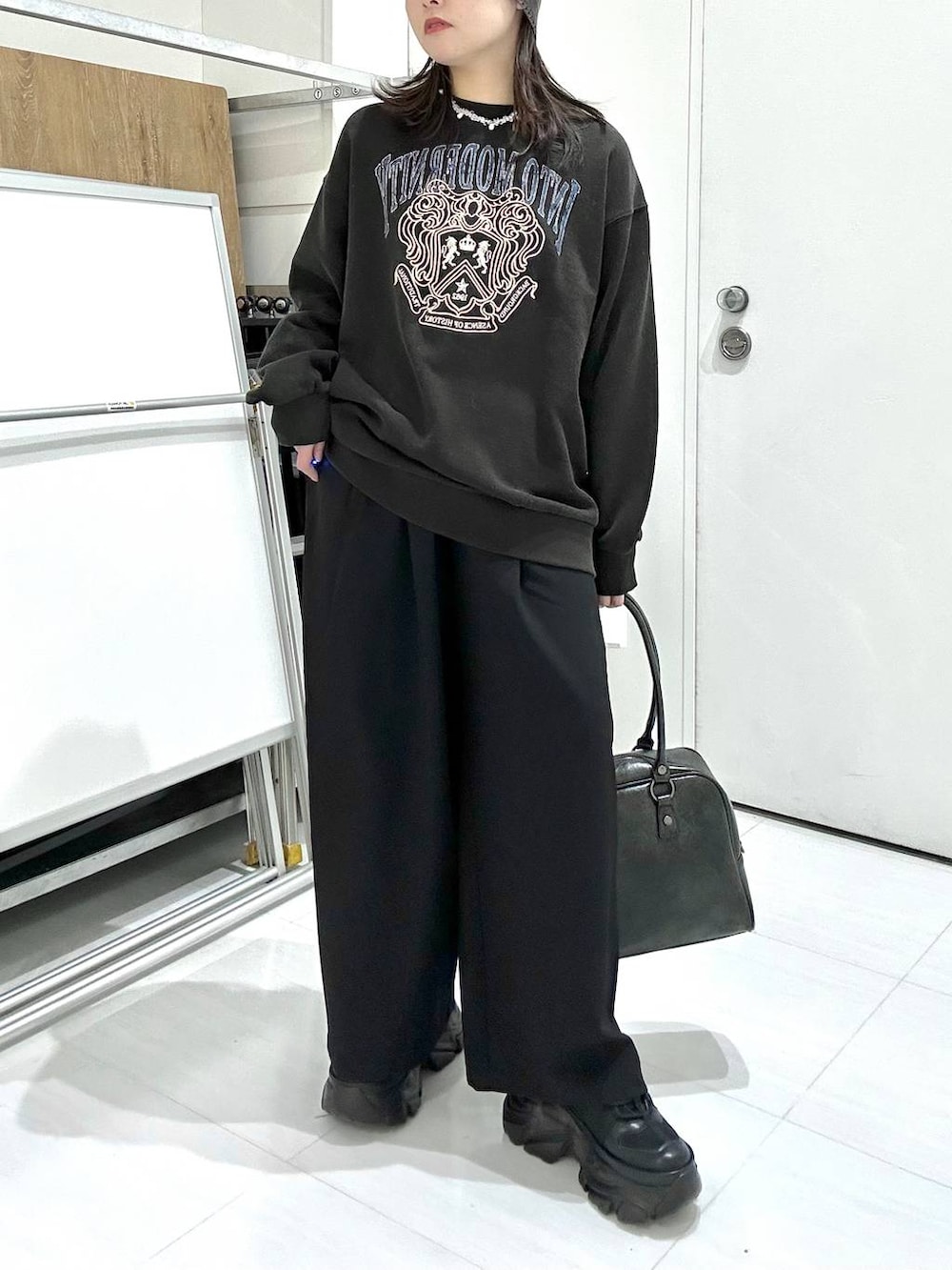 ブラック系のスニーカー、グレー系のボストンバッグ、グレー系のスウェットを着用したレディースの冬コーディネートの3枚目の写真