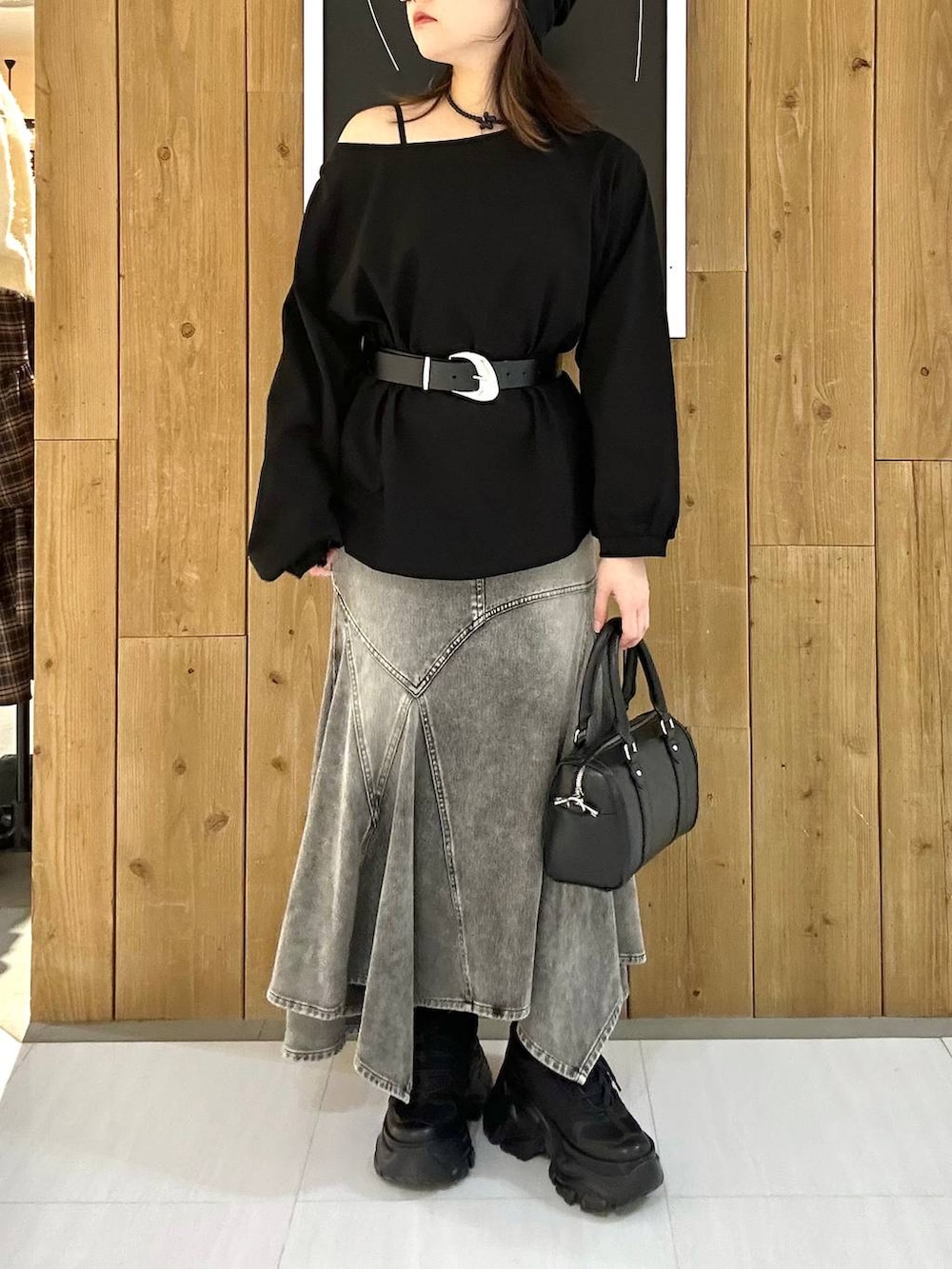 ブラック系のスニーカー、ブラック系のボストンバッグ、ブラック系のTシャツ/カットソーを着用したレディースの冬コーディネートの9枚目の写真