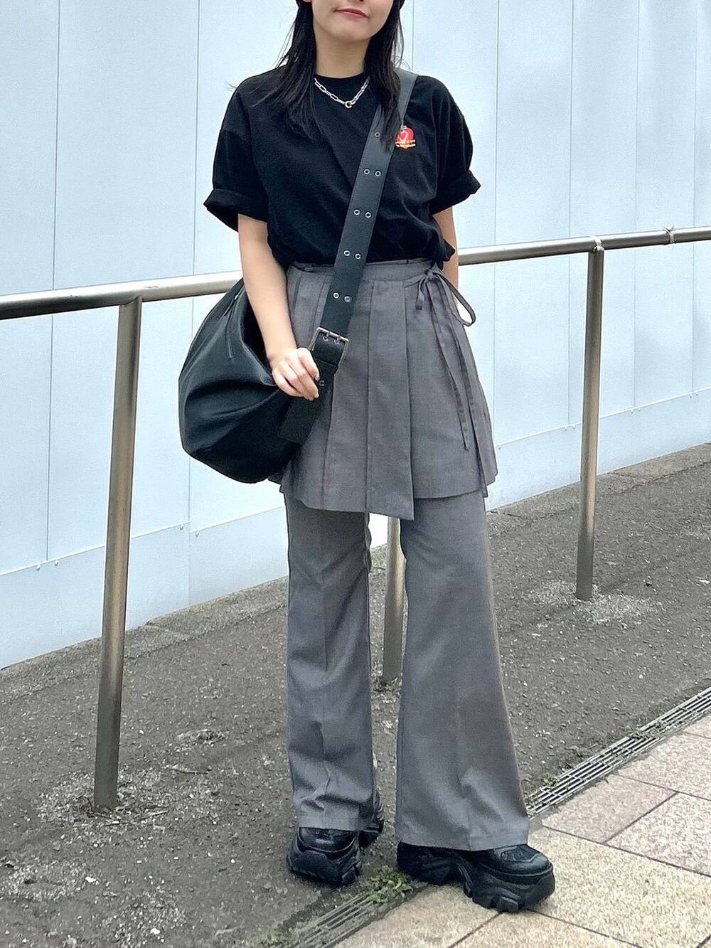 ブラック系のショルダーバッグ、グレー系のスカート、グレー系のスラックスを着用したレディースの春コーディネートの6枚目の写真