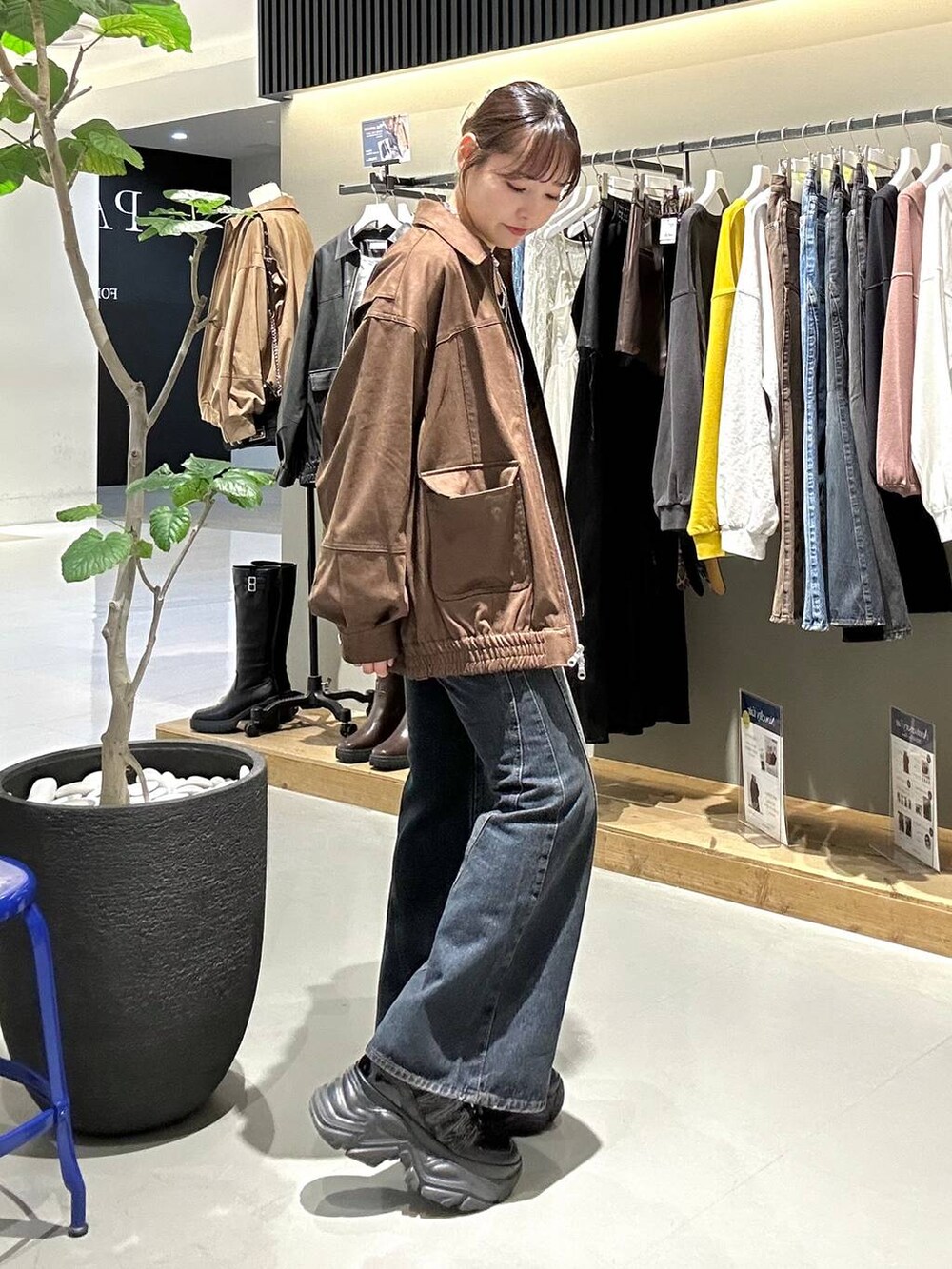 ブラック系のスニーカー、ブルー系のデニムパンツ、ブラック系のTシャツ/カットソーを着用したレディースの秋コーディネートの4枚目の写真