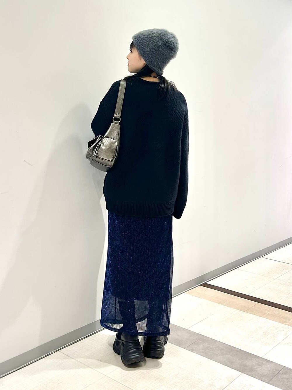 ブラック系のブーツ、その他のショルダーバッグ、ブルー系のニット/セーターを着用したレディースの秋コーディネートの5枚目の写真