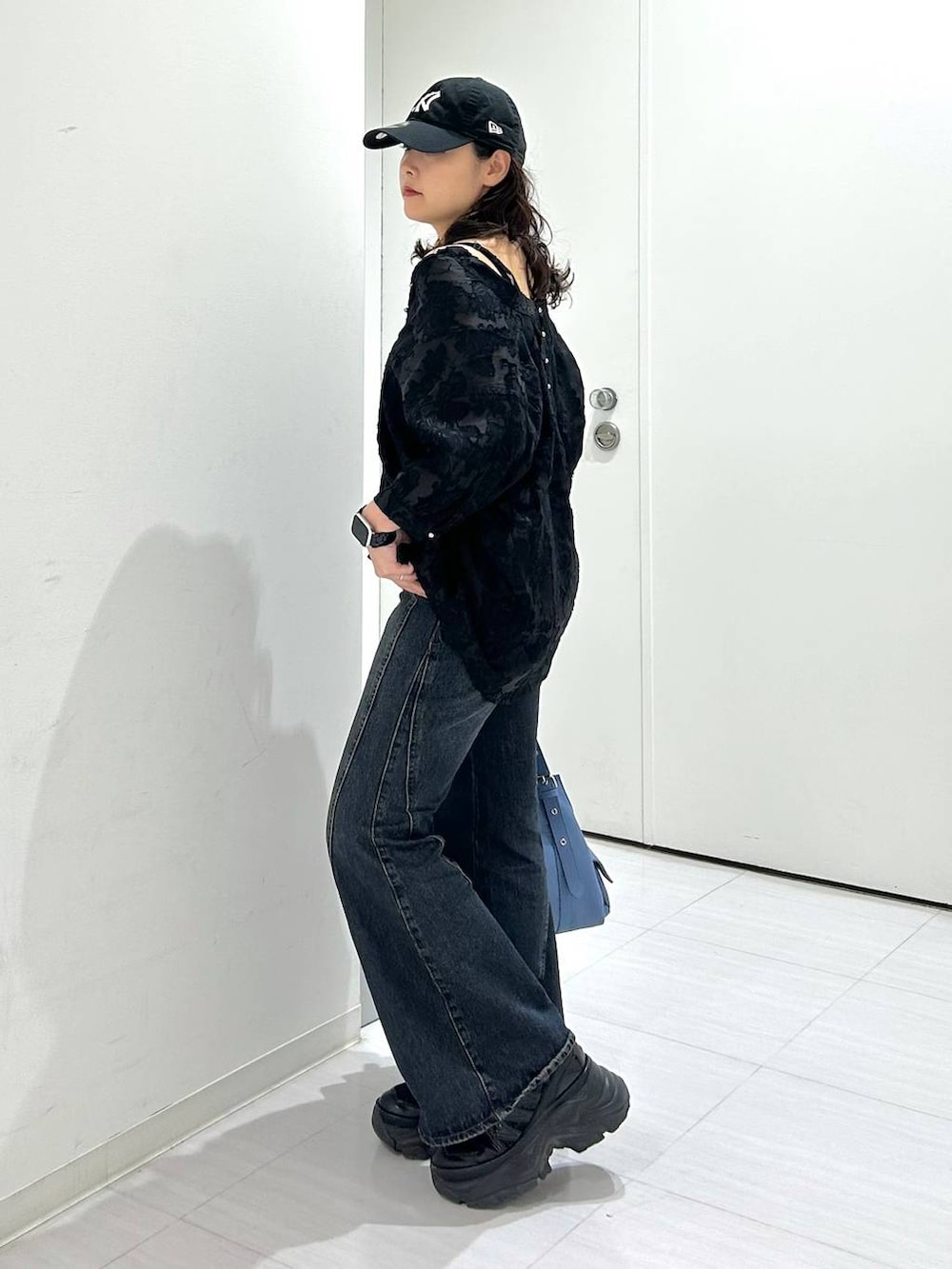 ブラック系のキャミソール、ブルー系のデニムパンツ、ブルー系のハンドバッグを着用したレディースの夏コーディネートの5枚目の写真