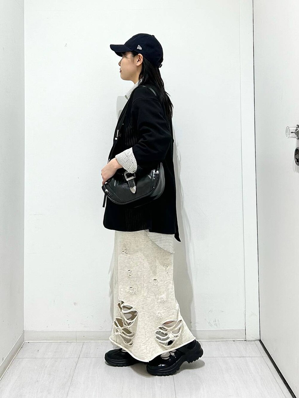 ブラック系のスニーカー、ブラック系のテーラードジャケット、ブラック系のショルダーバッグを着用したレディースの春コーディネートの4枚目の写真