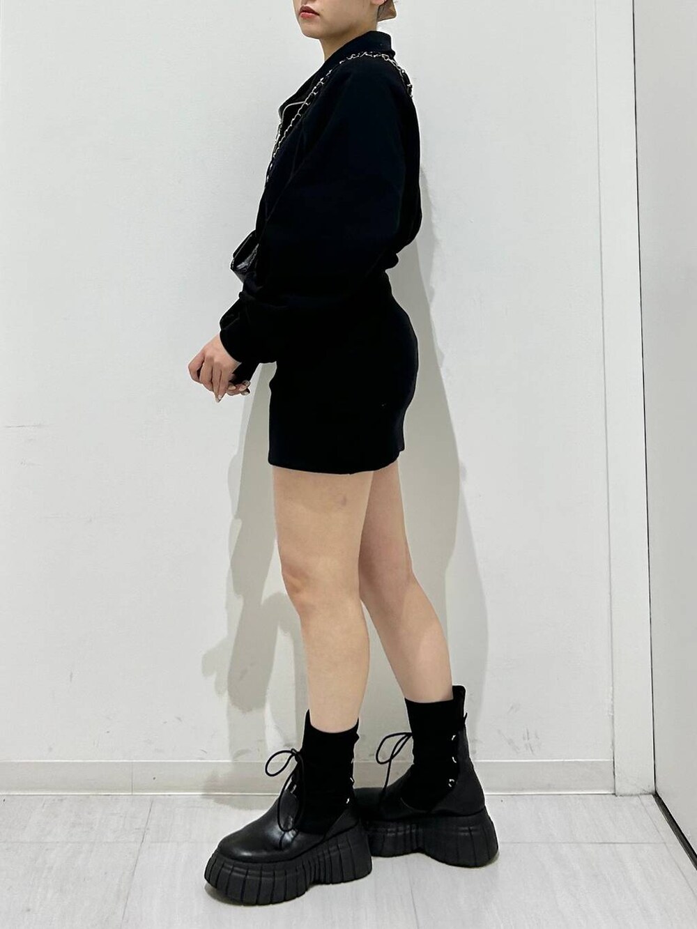 ブラック系のワンピース、ブラック系のブーツ、ブラック系のショルダーバッグを着用したレディースの冬コーディネートの3枚目の写真