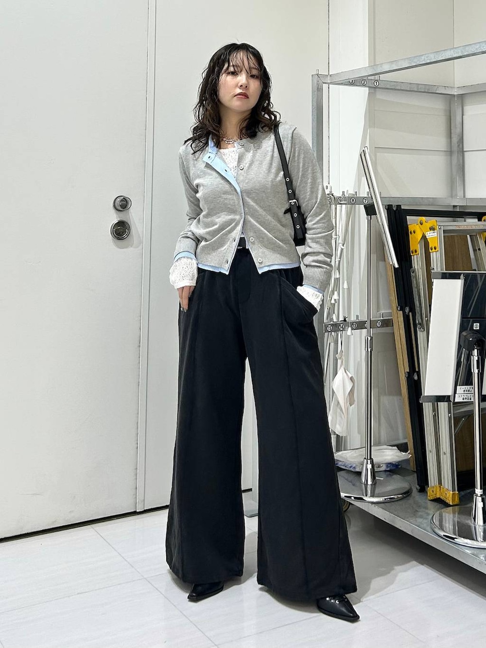 ブラック系のスウェットパンツ、グレー系のカーディガン/ボレロ、ホワイト系のTシャツ/カットソーを着用したレディースの冬コーディネートの2枚目の写真