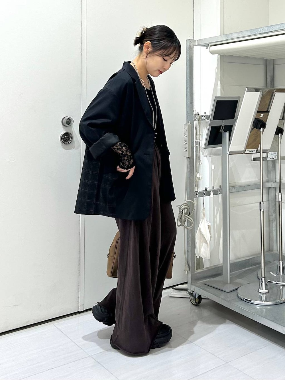 ベージュ系のボストンバッグ、ブラック系のスウェットパンツ、ブラック系のテーラードジャケットを着用したレディースの秋コーディネートの7枚目の写真