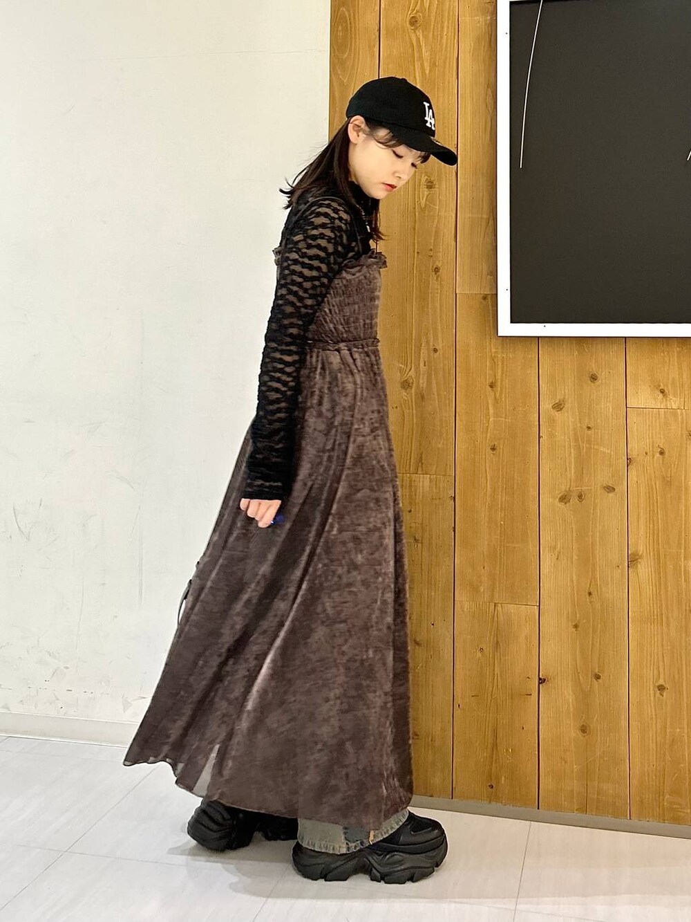 ブルー系のデニムパンツ、ブラック系のブーツ、ブラック系のキャミソールを着用したレディースの秋コーディネートの4枚目の写真