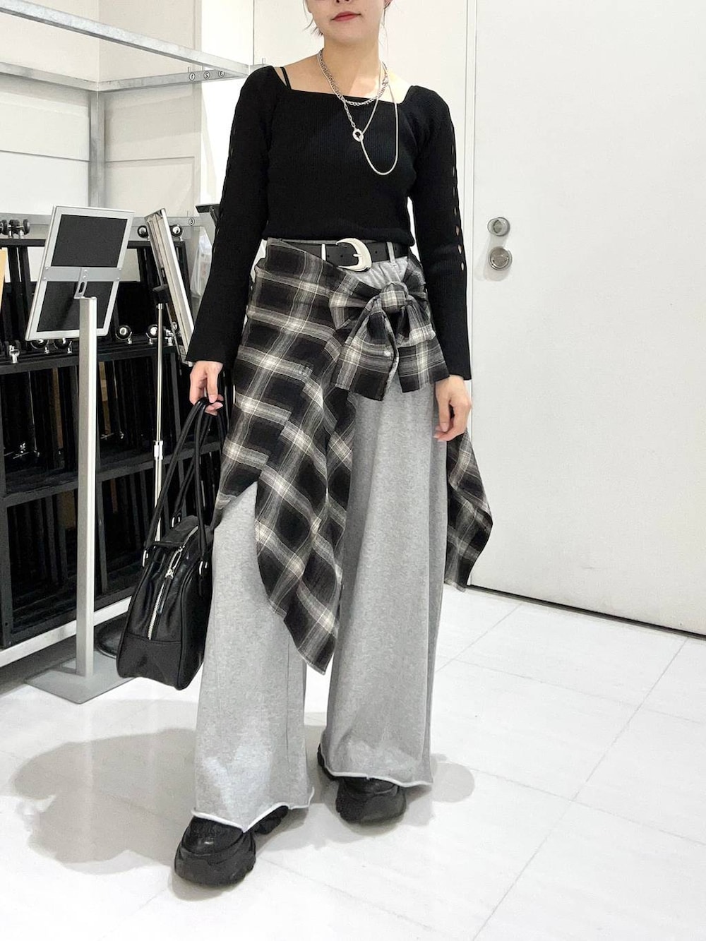 ブラック系のスニーカー、グレー系のスウェットパンツ、ブラック系のシャツ/ブラウスを着用したレディースの秋コーディネートの2枚目の写真