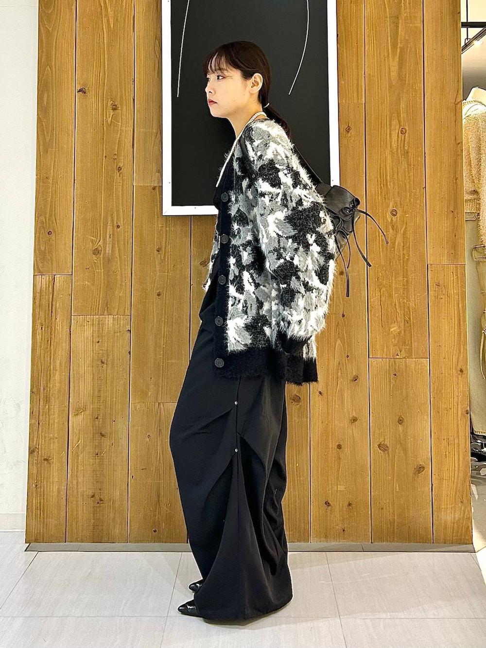 ブラック系のタンクトップ、ブラック系のパンプス、ブラック系のショルダーバッグを着用したレディースの秋コーディネートの4枚目の写真