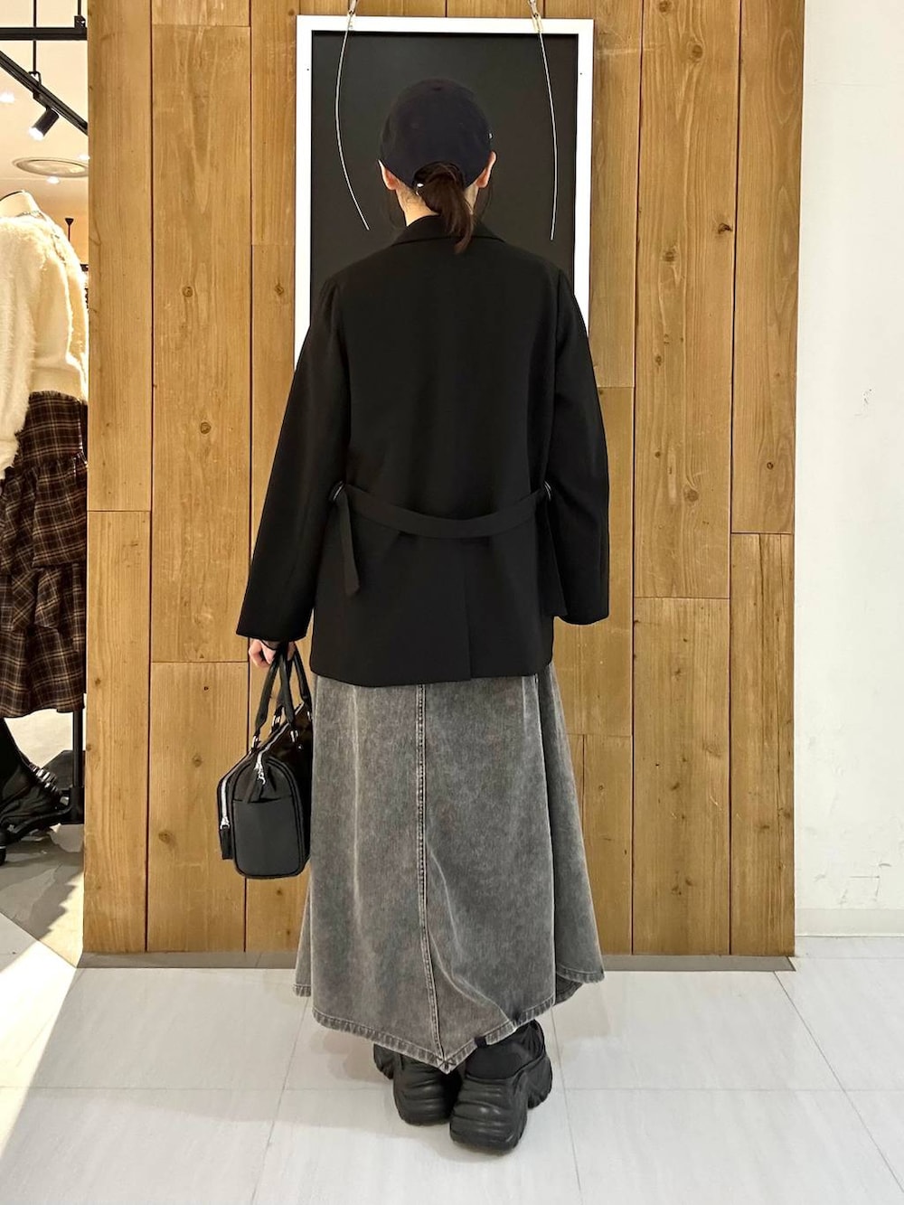 ブラック系のスニーカー、ブラック系のテーラードジャケット、ブラック系のショルダーバッグを着用したレディースの冬コーディネートの6枚目の写真