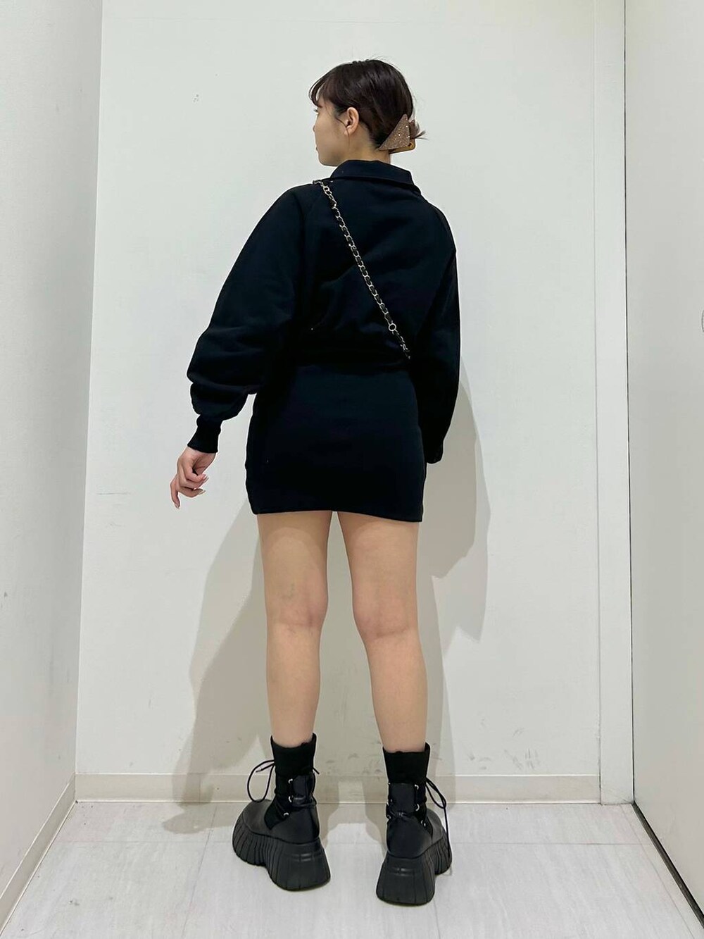 ブラック系のワンピース、ブラック系のブーツ、ブラック系のショルダーバッグを着用したレディースの冬コーディネートの4枚目の写真