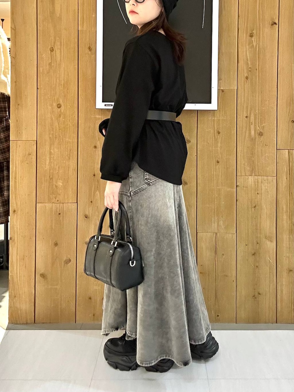 ブラック系のスニーカー、ブラック系のボストンバッグ、ブラック系のTシャツ/カットソーを着用したレディースの冬コーディネートの6枚目の写真