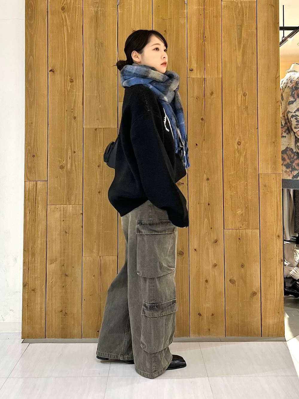 ブラック系のショルダーバッグ、ブラック系のニット/セーター、ブラック系のデニムパンツを着用したレディースの冬コーディネートの6枚目の写真