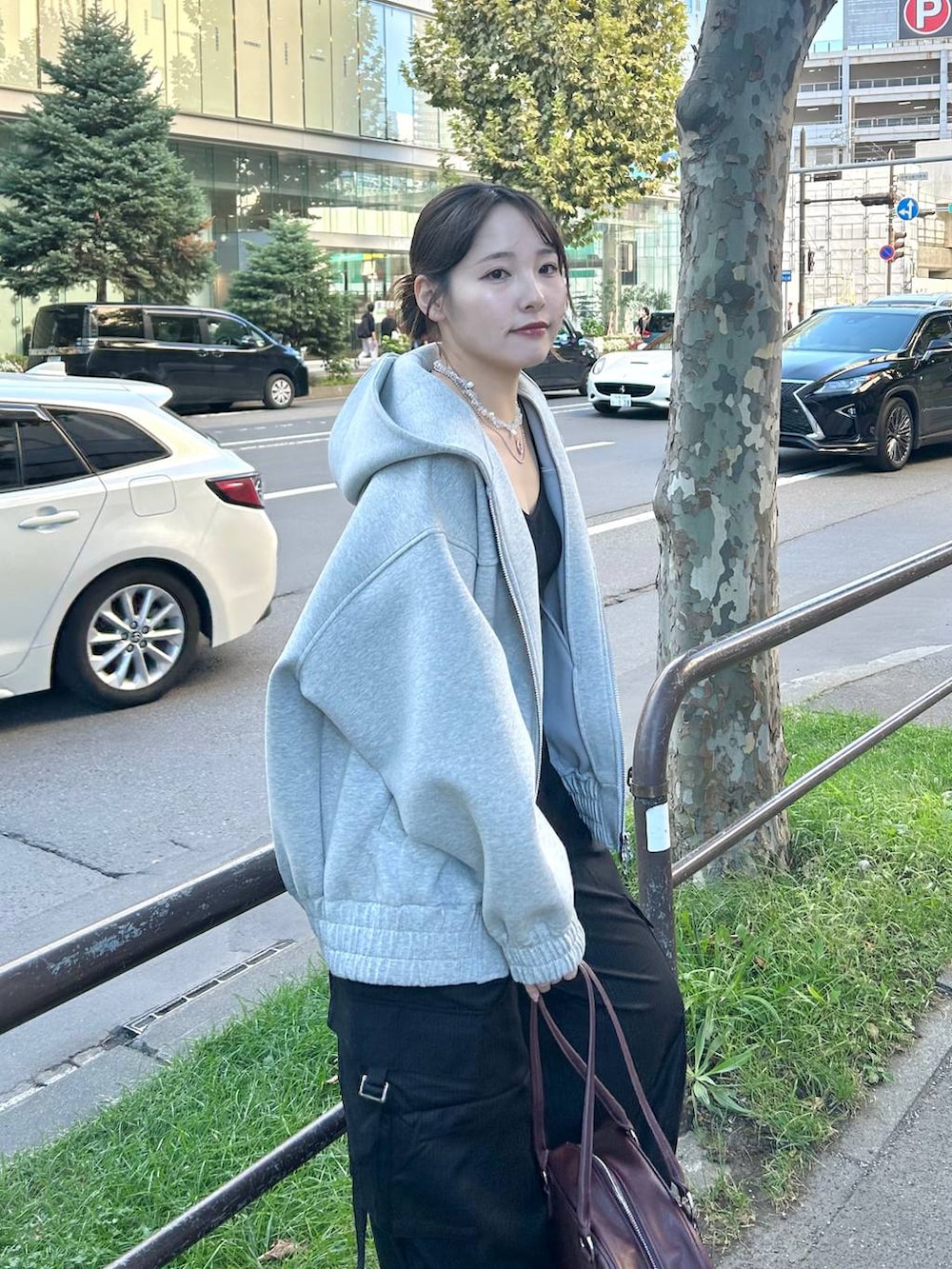 グレー系のパーカー、レッド系のボストンバッグ、ブラック系のスラックスを着用したレディースの秋コーディネートの8枚目の写真