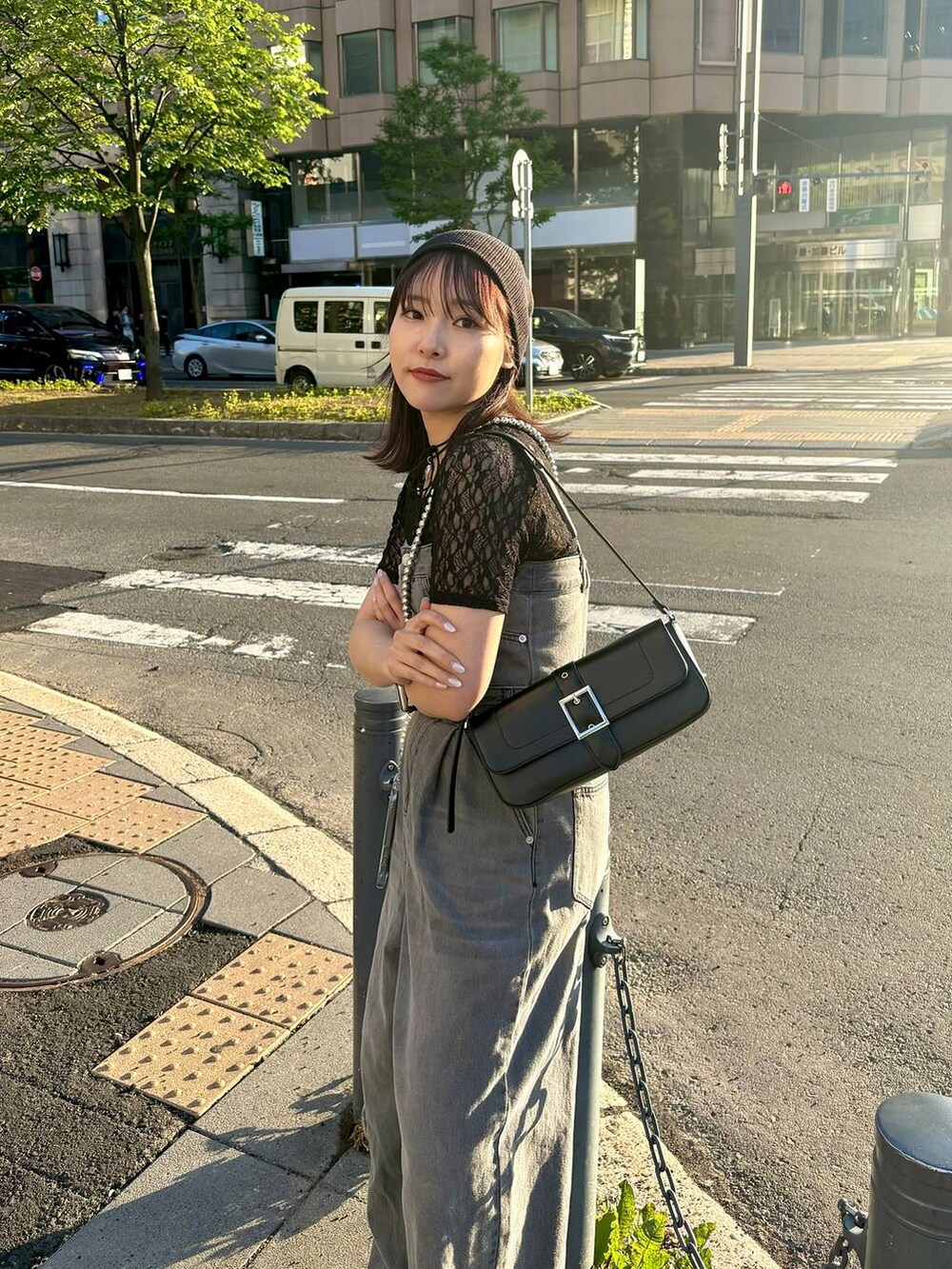 ブラック系のサロペット/オーバーオール、ブラック系のTシャツ/カットソー、ブラック系のハンドバッグを着用したレディースの夏コーディネートの2枚目の写真