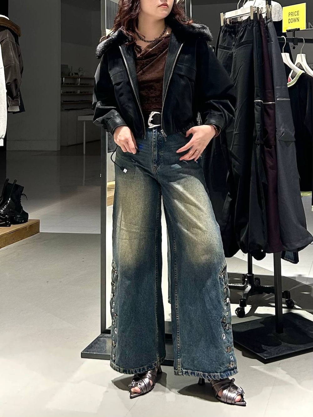 ブラック系のブルゾン、ブルー系のデニムパンツ、ブラウン系のTシャツ/カットソーを着用したレディースの秋コーディネートの2枚目の写真