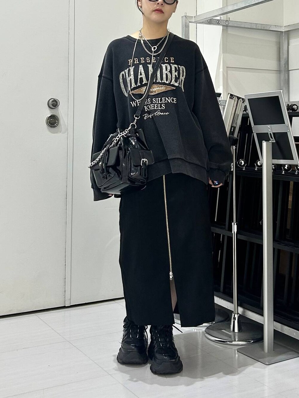 ブラック系のショルダーバッグ、グレー系のスウェット、ブラック系のスカートを着用したレディースの秋コーディネートの3枚目の写真