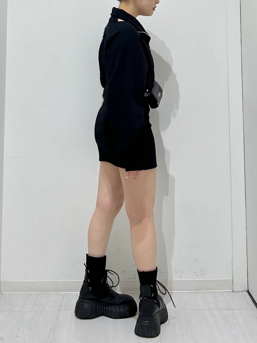 ブラック系のワンピース、ブラック系のブーツ、ブラック系のショルダーバッグを着用したレディースの冬コーディネートの5枚目の写真