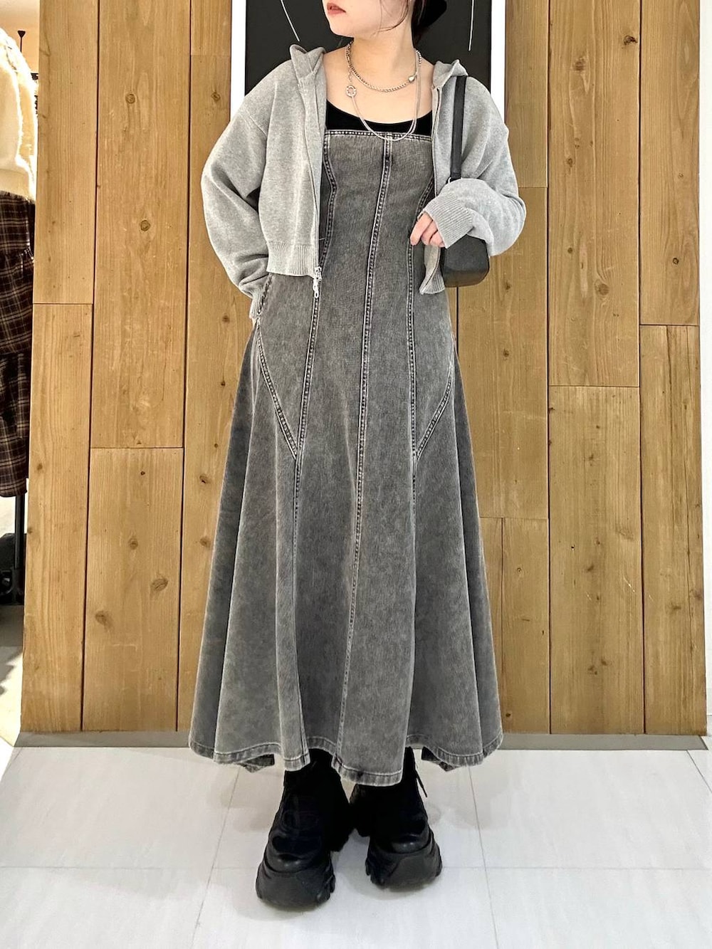 ブラック系のスニーカー、ブルー系のパーカー、ブラック系のハンドバッグを着用したレディースの冬コーディネートの2枚目の写真