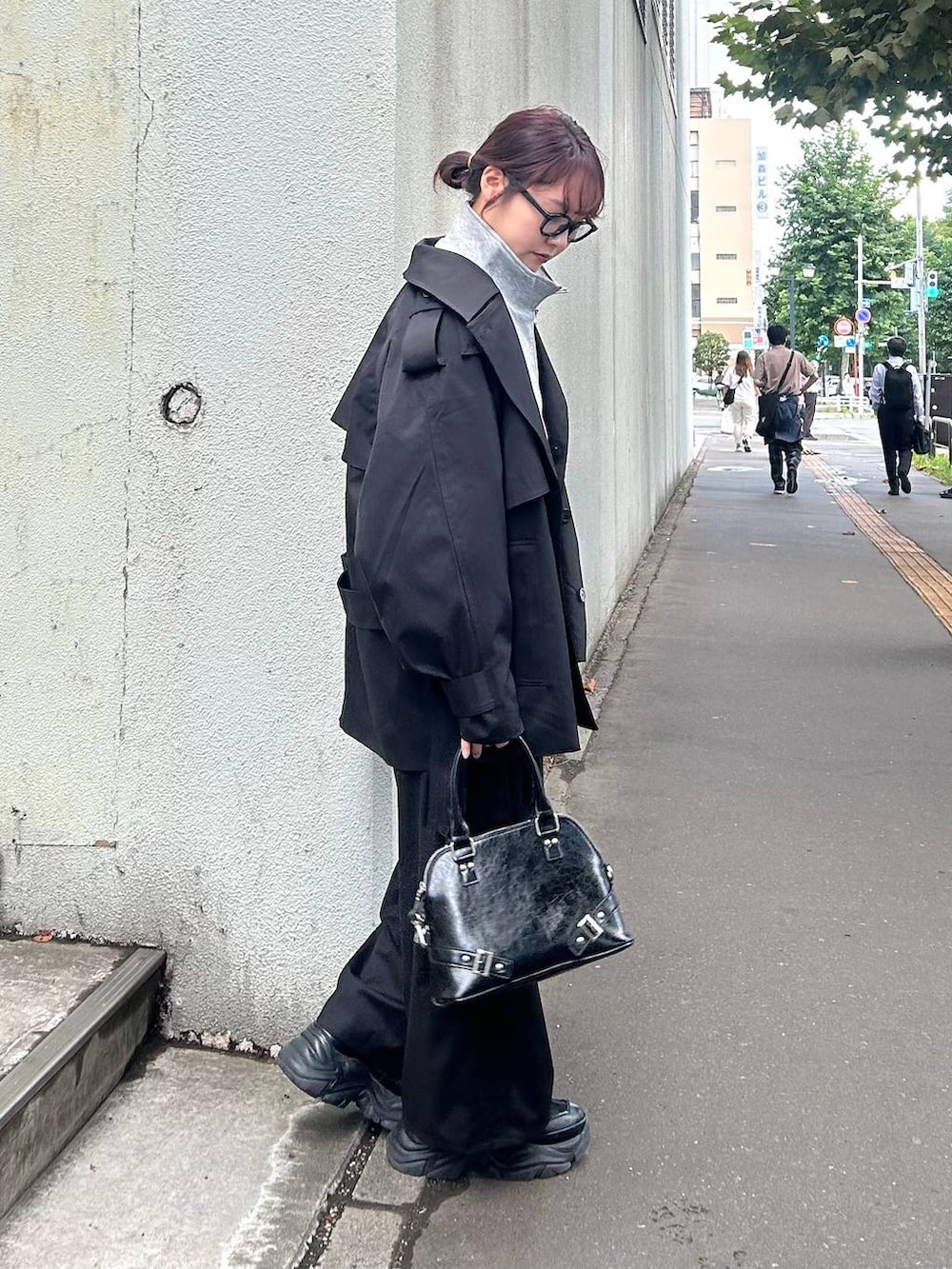 ブラック系のスニーカー、ブラック系のショルダーバッグ、グレー系のブルゾンを着用したレディースの秋コーディネートの4枚目の写真