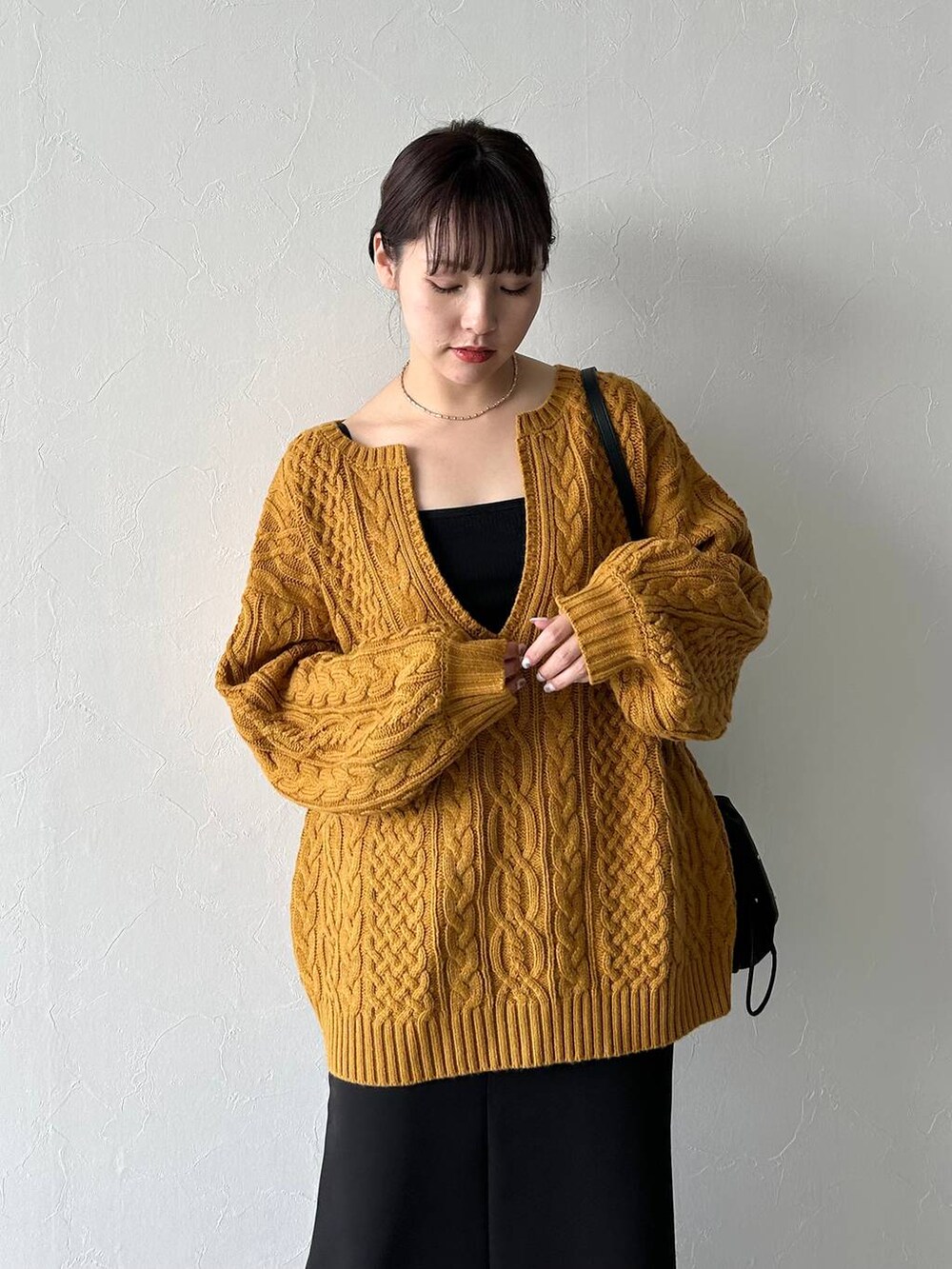 ブラック系のスカート、ブラック系のキャミソール、イエロー系のニット/セーターを着用したレディースの秋コーディネートの7枚目の写真