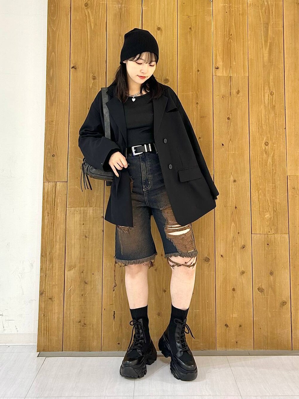 ブラック系のテーラードジャケット、ブラック系のショルダーバッグ、ブラック系のブーツを着用したレディースの秋コーディネートの7枚目の写真