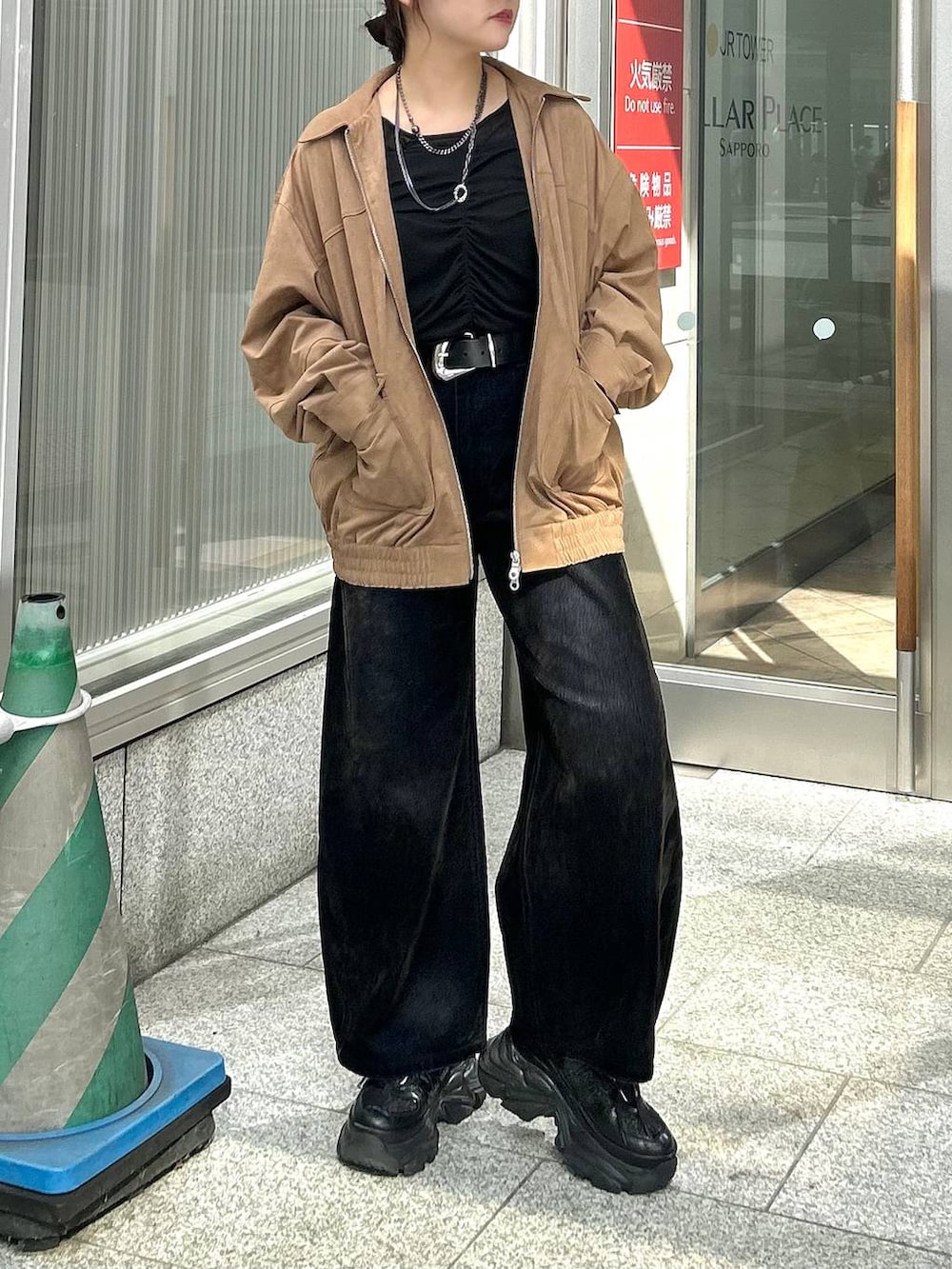 ブラック系のデニムパンツ、イエロー系のブルゾン、ブラック系のTシャツ/カットソーを着用したレディースの秋コーディネートの4枚目の写真