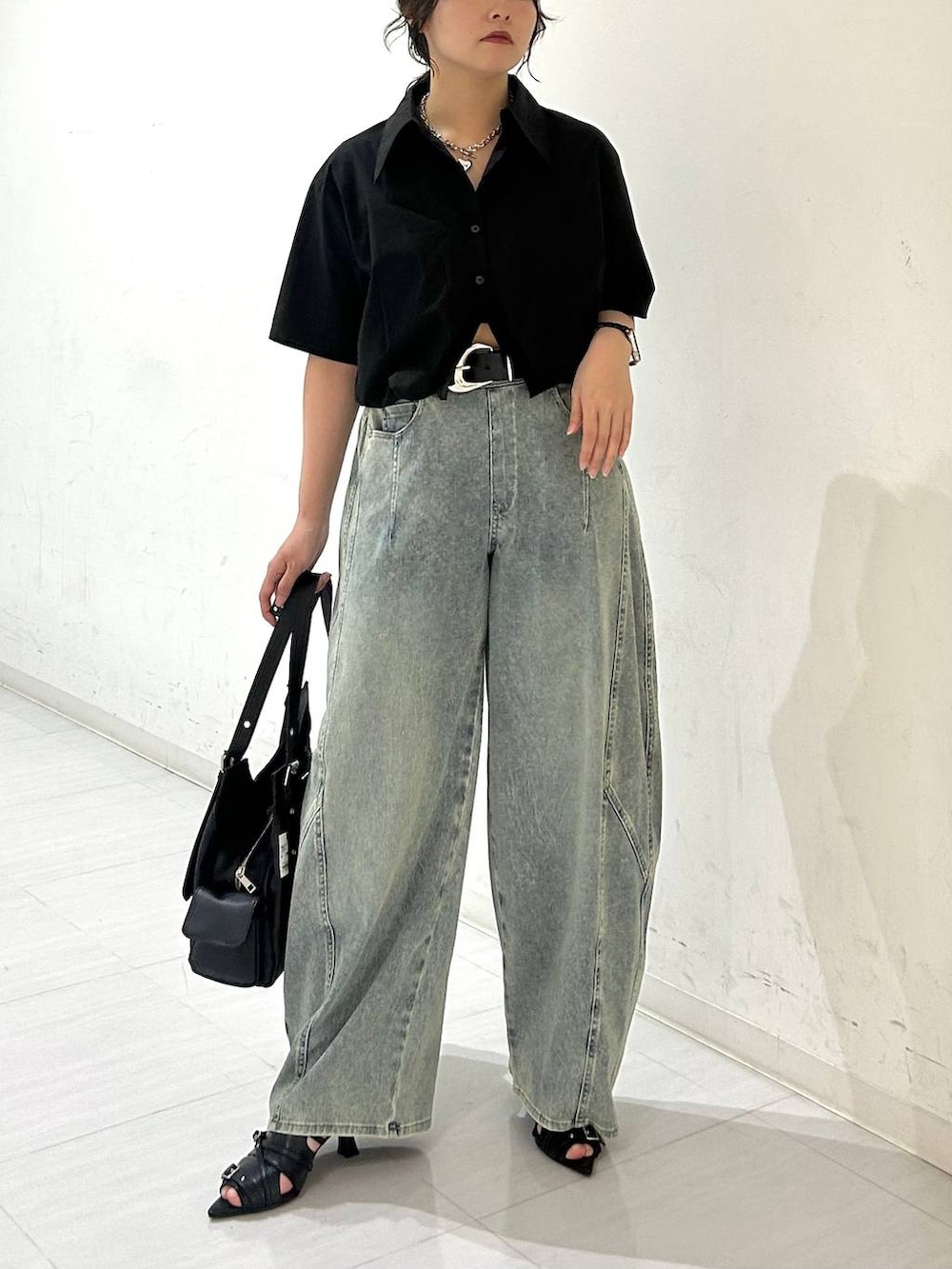 ブルー系のデニムパンツ、ブラック系のサンダル、ブラック系のベルトを着用したレディースの夏コーディネートの3枚目の写真