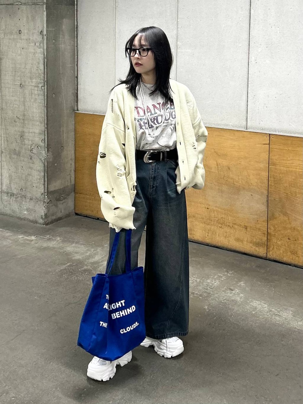 ホワイト系のスニーカー、ブルー系のデニムパンツ、ブルー系のトートバッグを着用したレディースの春コーディネートの2枚目の写真