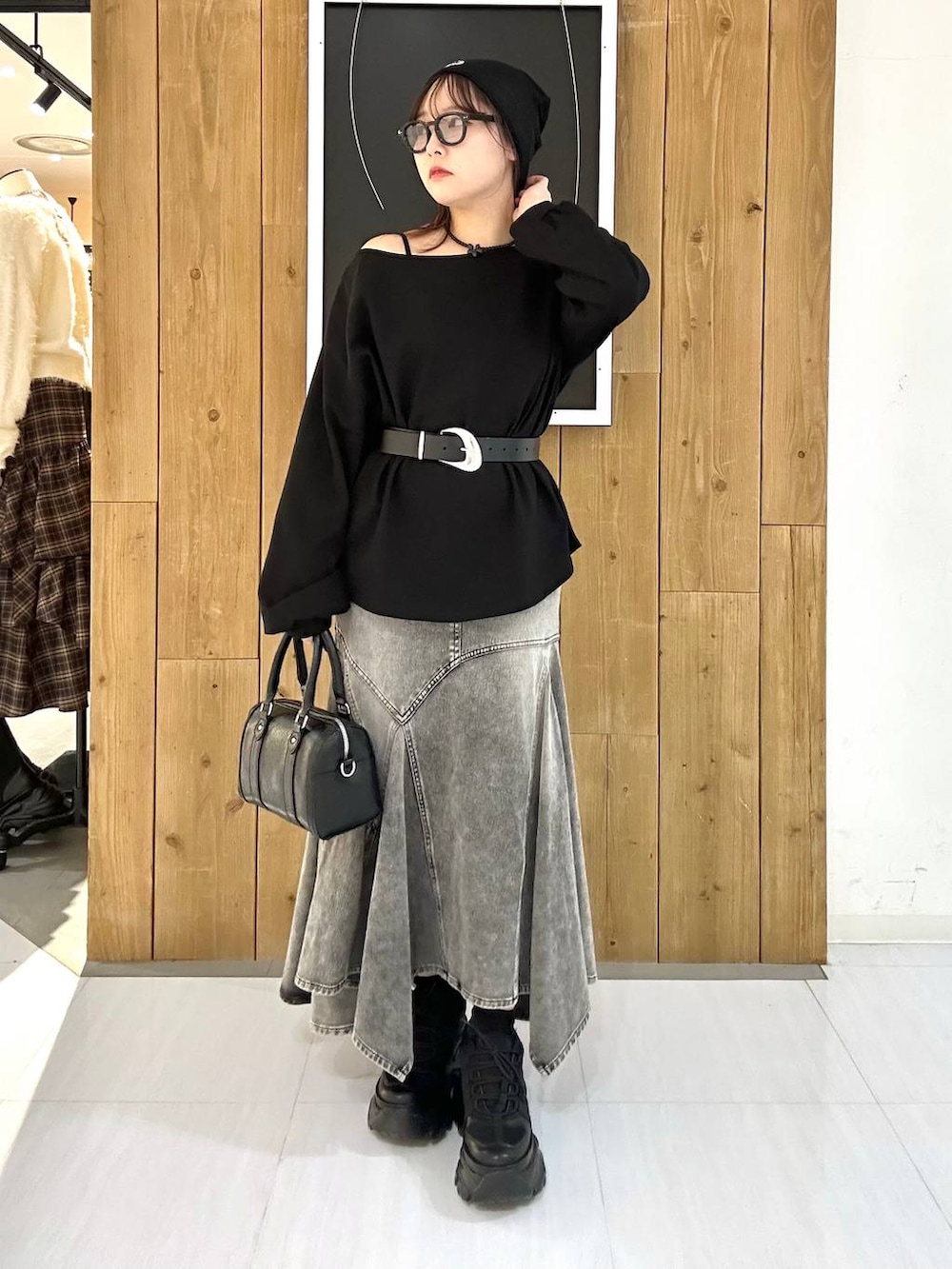 ブラック系のスニーカー、ブラック系のボストンバッグ、ブラック系のTシャツ/カットソーを着用したレディースの冬コーディネートの2枚目の写真