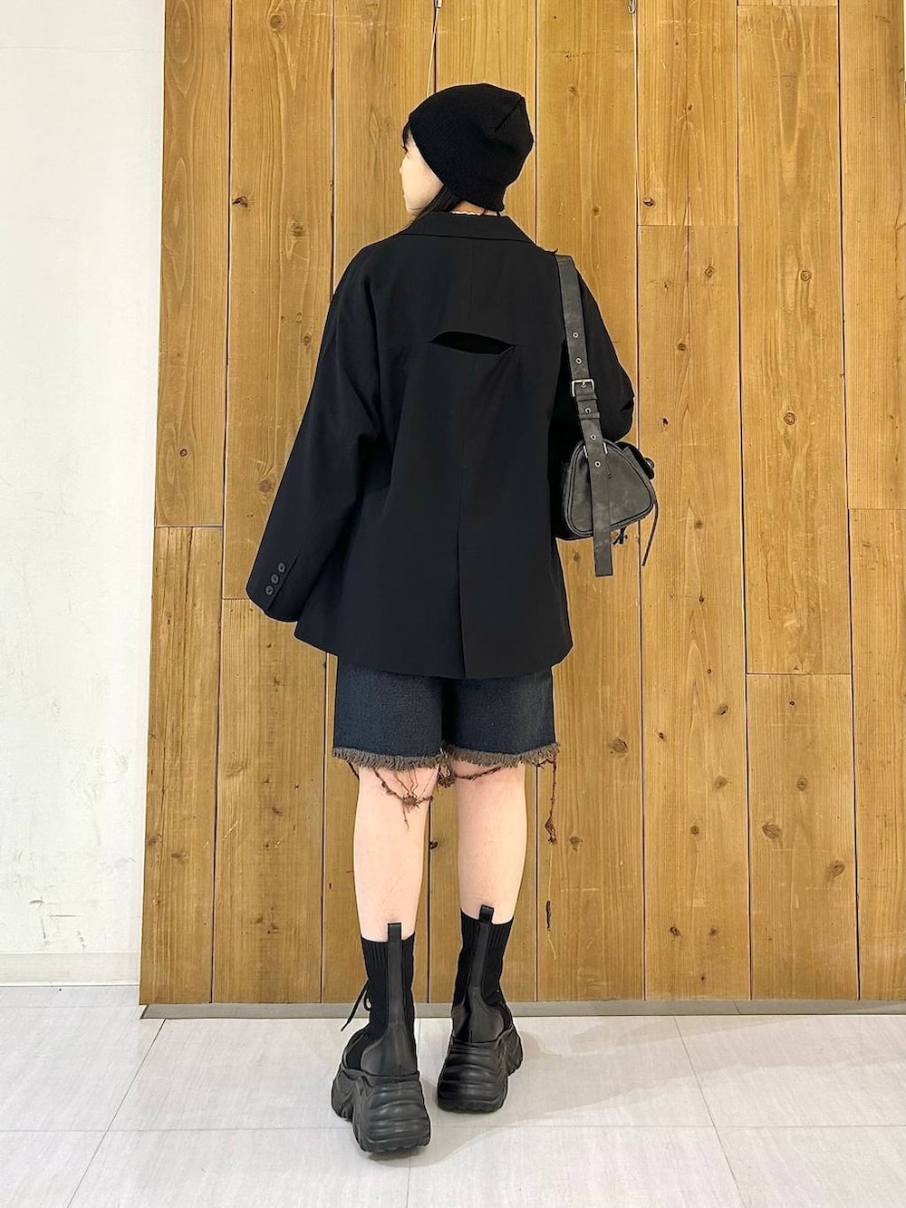 ブラック系のテーラードジャケット、ブラック系のショルダーバッグ、ブラック系のブーツを着用したレディースの秋コーディネートの6枚目の写真