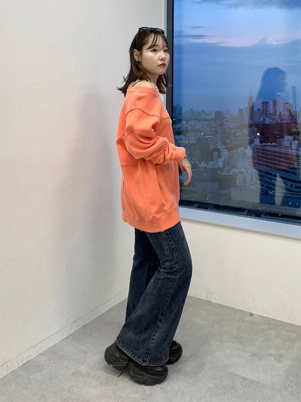 ブルー系のデニムパンツ、ピンク系のスウェットを着用したレディースの秋コーディネートの4枚目の写真