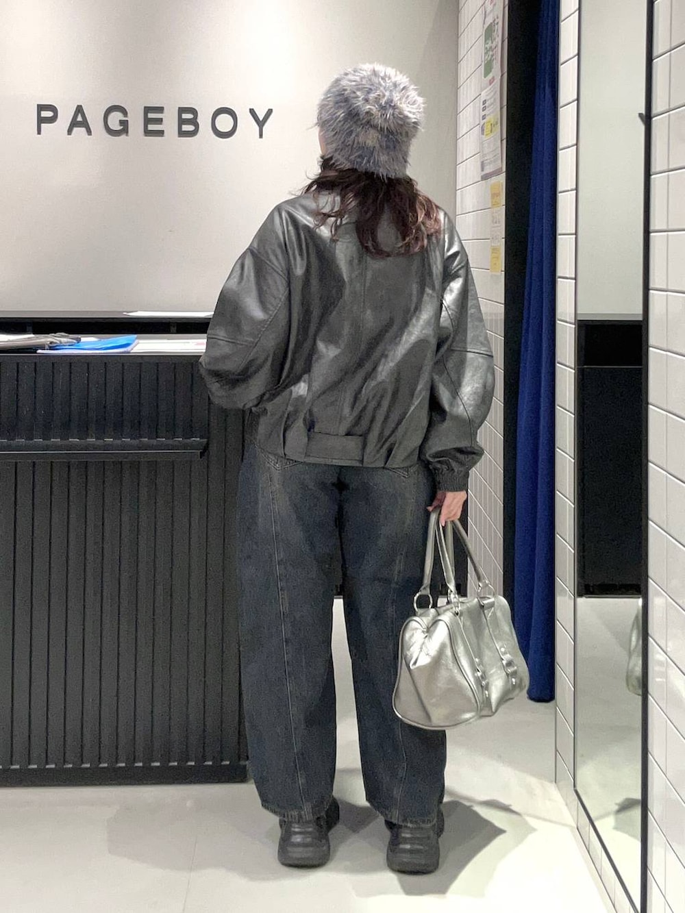 ブルー系のデニムパンツ、ブラック系のスニーカー、ブラック系のライダースジャケットを着用したレディースの秋コーディネートの5枚目の写真