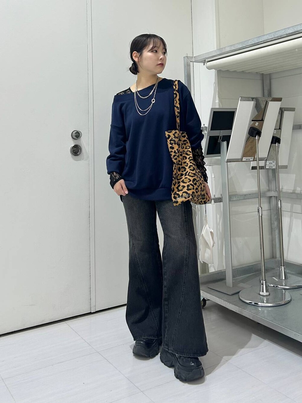 ブラック系のスニーカー、ブルー系のデニムパンツ、ブラック系のTシャツ/カットソーを着用したレディースの秋コーディネートの2枚目の写真