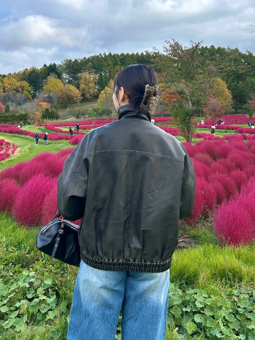 ブラック系のボストンバッグ、ブラック系のブルゾンを着用したレディースの秋コーディネートの3枚目の写真