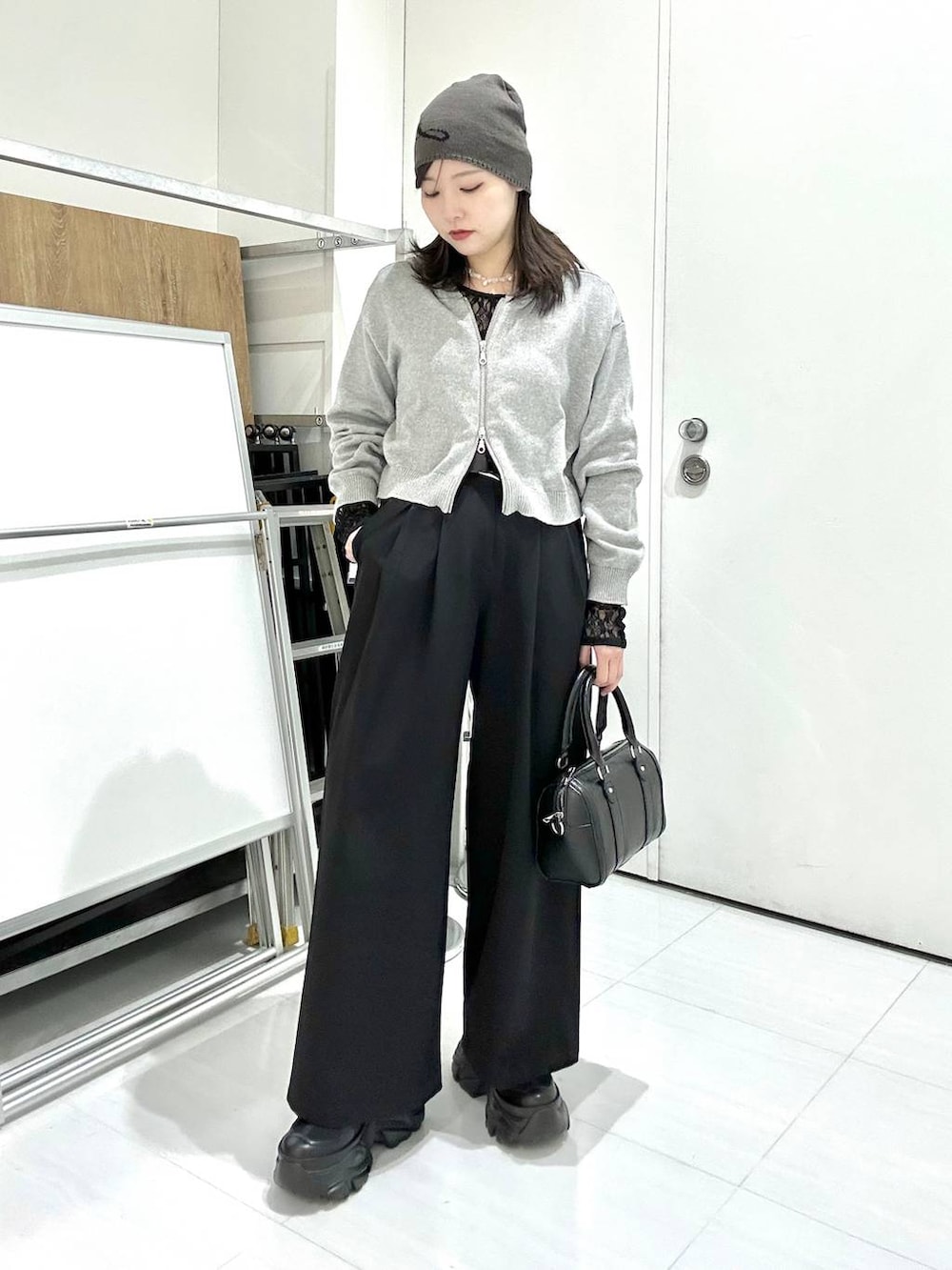 ブラック系のスニーカー、ブラック系のTシャツ/カットソー、ブラック系のボストンバッグを着用したレディースの冬コーディネートの7枚目の写真