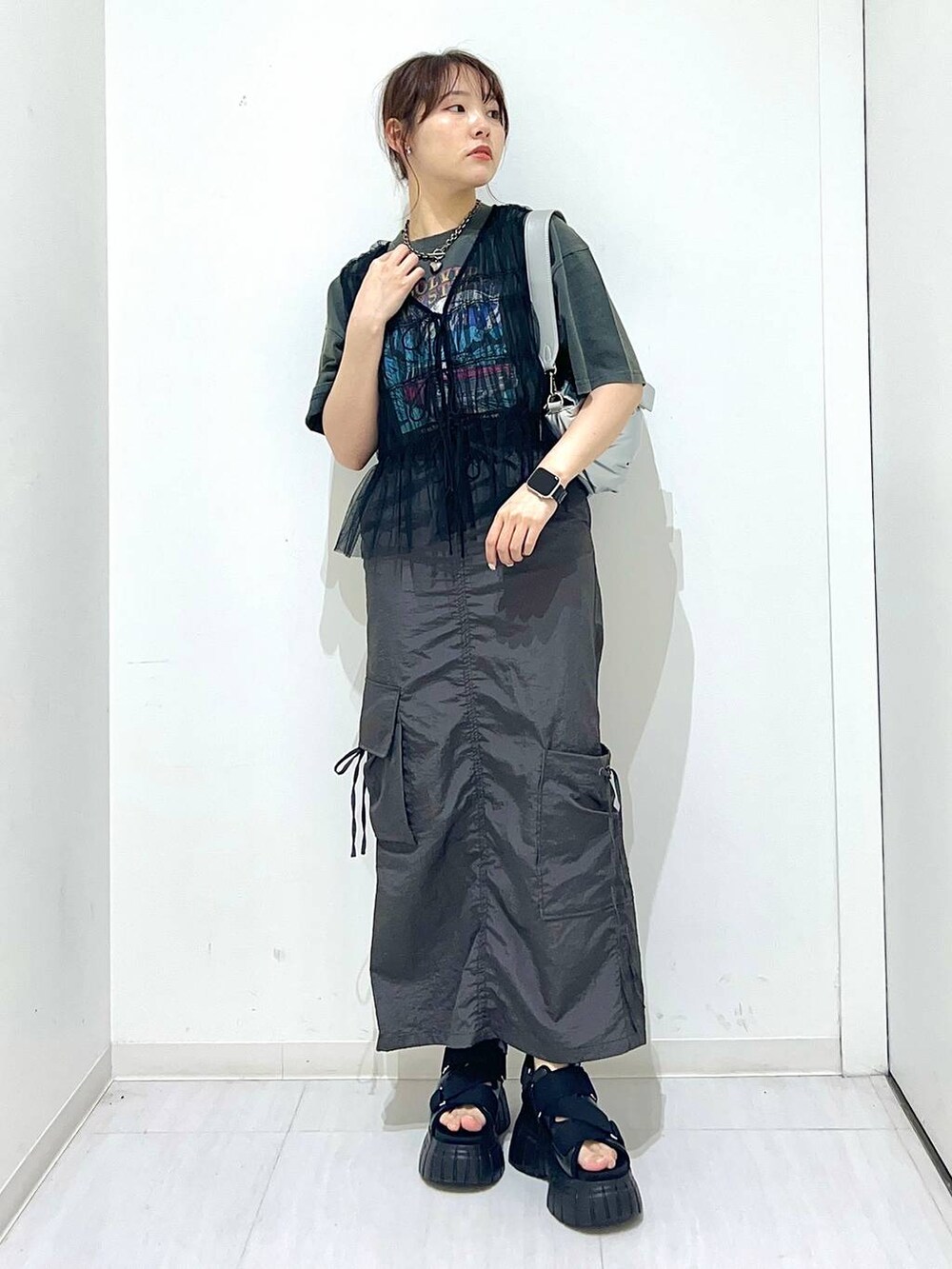 ブラック系のスニーカー、グレー系のTシャツ/カットソー、シルバー系のショルダーバッグを着用したレディースの夏コーディネートの2枚目の写真