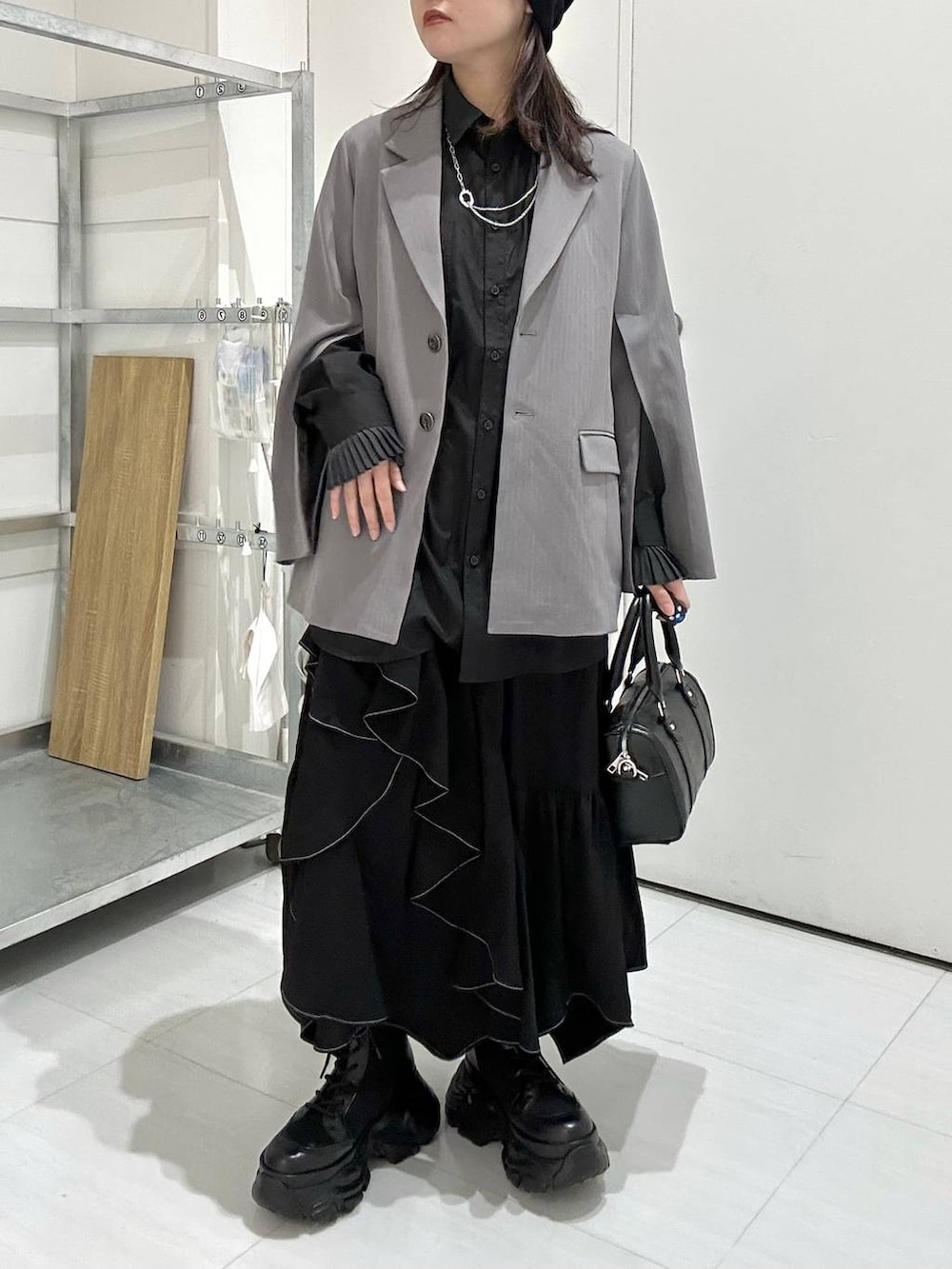 ブラック系のブーツ、グレー系のテーラードジャケット、ブラック系のスカートを着用したレディースの冬コーディネートの4枚目の写真