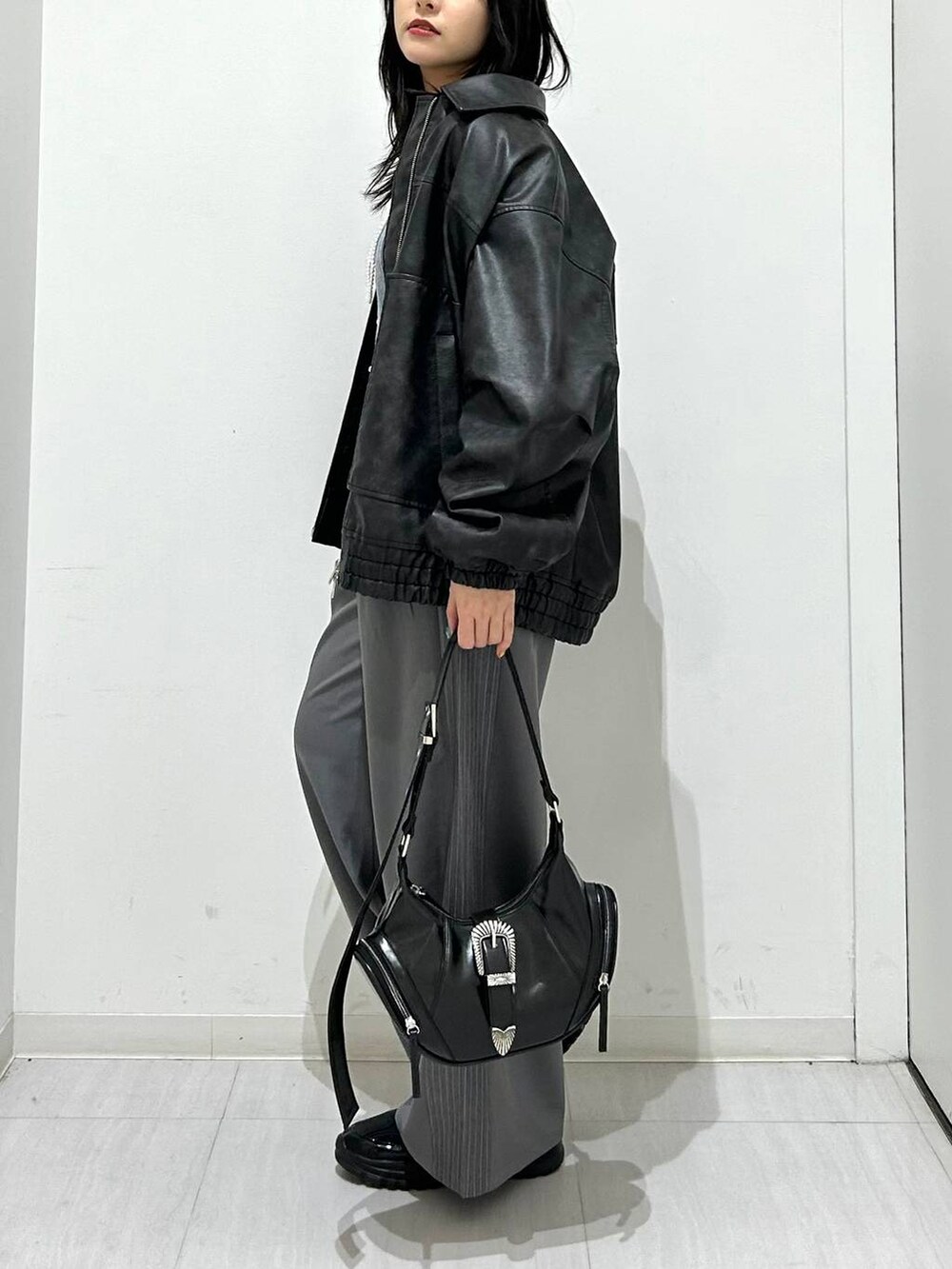 ブラック系のブルゾン、ブラック系のスニーカー、ブラック系のショルダーバッグを着用したレディースの春コーディネートの6枚目の写真