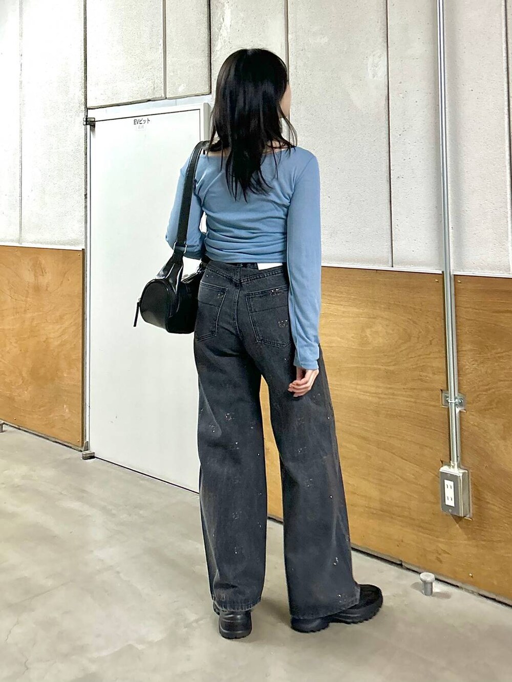 ブラック系のデニムパンツ、ブラック系のスニーカー、ブラック系のショルダーバッグを着用したレディースの春コーディネートの7枚目の写真