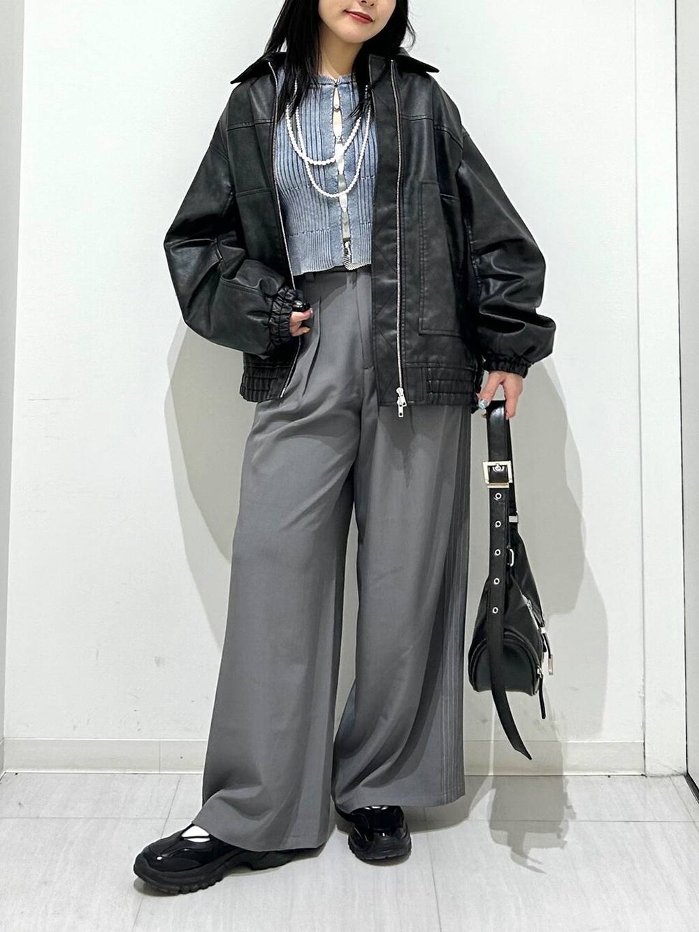 ブラック系のブルゾン、ブラック系のスニーカー、ブラック系のショルダーバッグを着用したレディースの春コーディネートの3枚目の写真